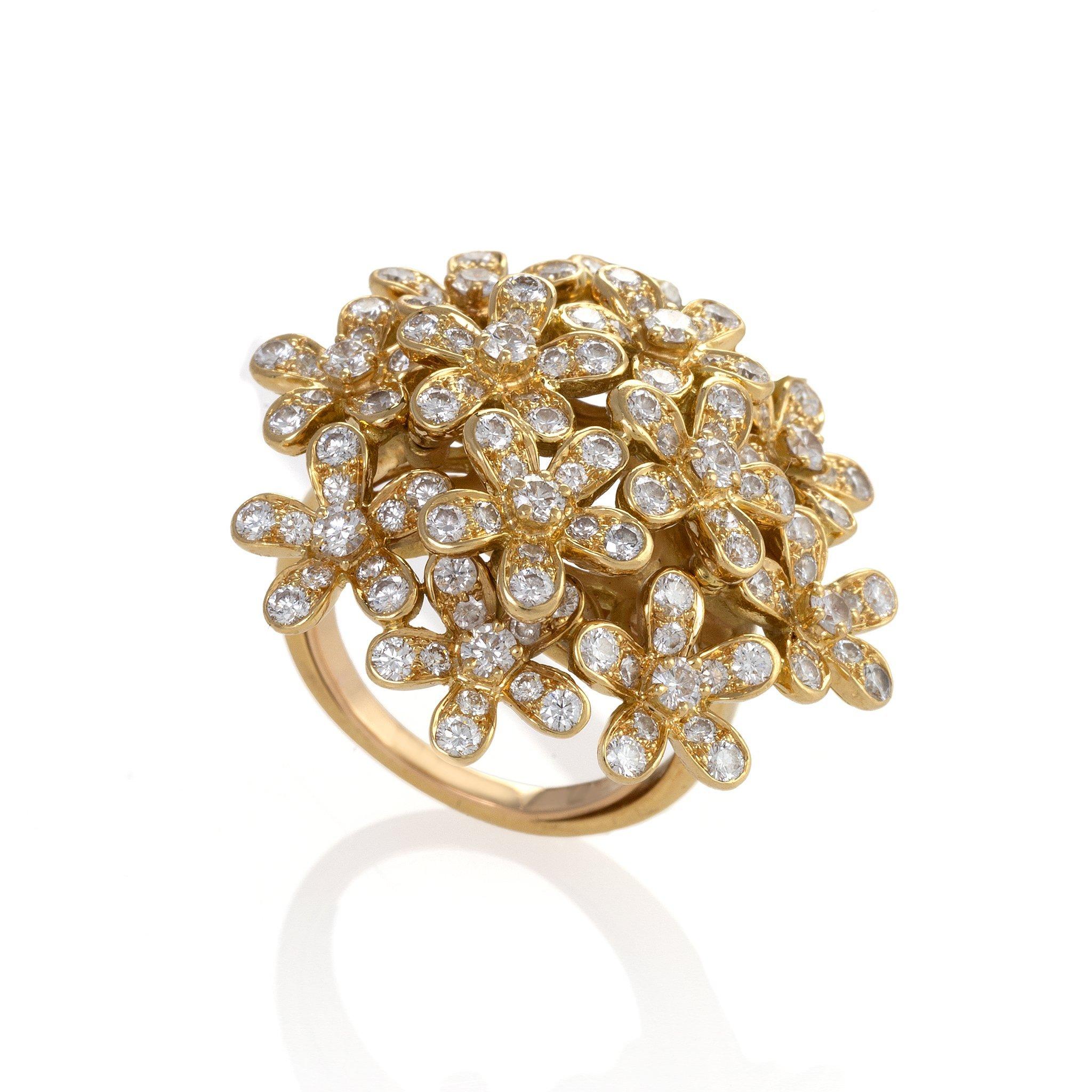 Of 21st century design, this “Socrate” ring by Van Cleef & Arpels is composed of diamonds and 18K gold. The bombé form ring is designed as a dense, naturalistic cluster of 5-petal diamond blossoms. Playful and opulent, this ring is a glittering