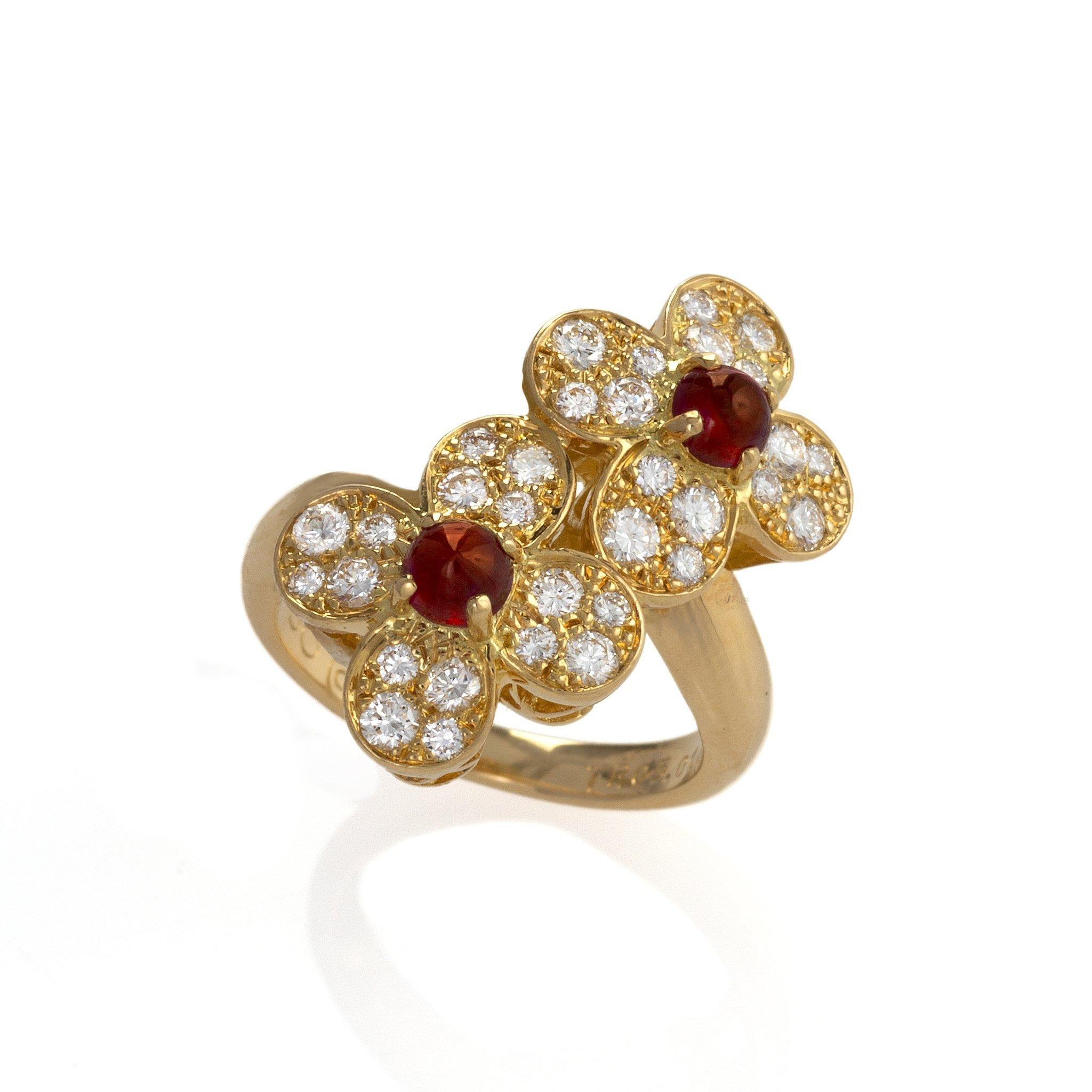 Created by Van Cleef & Arpels, this “Trefle” ring is composed of cabochon rubies and diamonds. The bypass form ring is designed as two pave-set diamond blossoms, each centering a cabochon ruby. This unusual twin-flower Trefle ring with its ruby