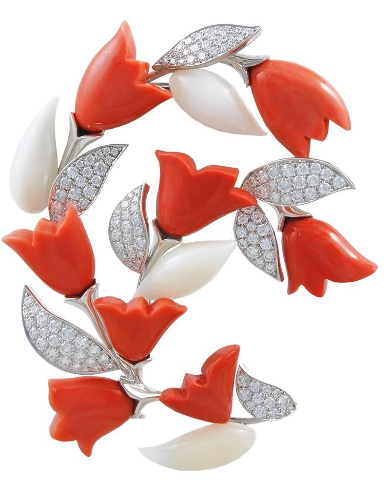 A 1980's Van Cleef & Arpels brooch & earring suite, the brooch designed as a curving branch with pave-set diamond leaves and white & pink carved coral flowers. 

The ear clips are similarly designed, but as single flowers with pink coral, flower