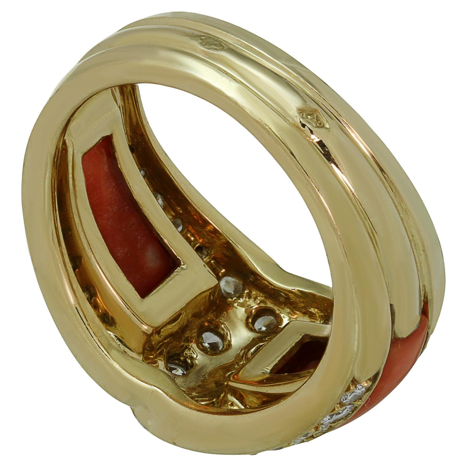 This stunning Van Cleef & Arpels ring is crafted in 18k yellow gold and set with coral surrounded with sparkling brilliant-cut round diamonds of an estimated 0.87 carats. The genuine coral has an orange color with natural white spots. Made in France