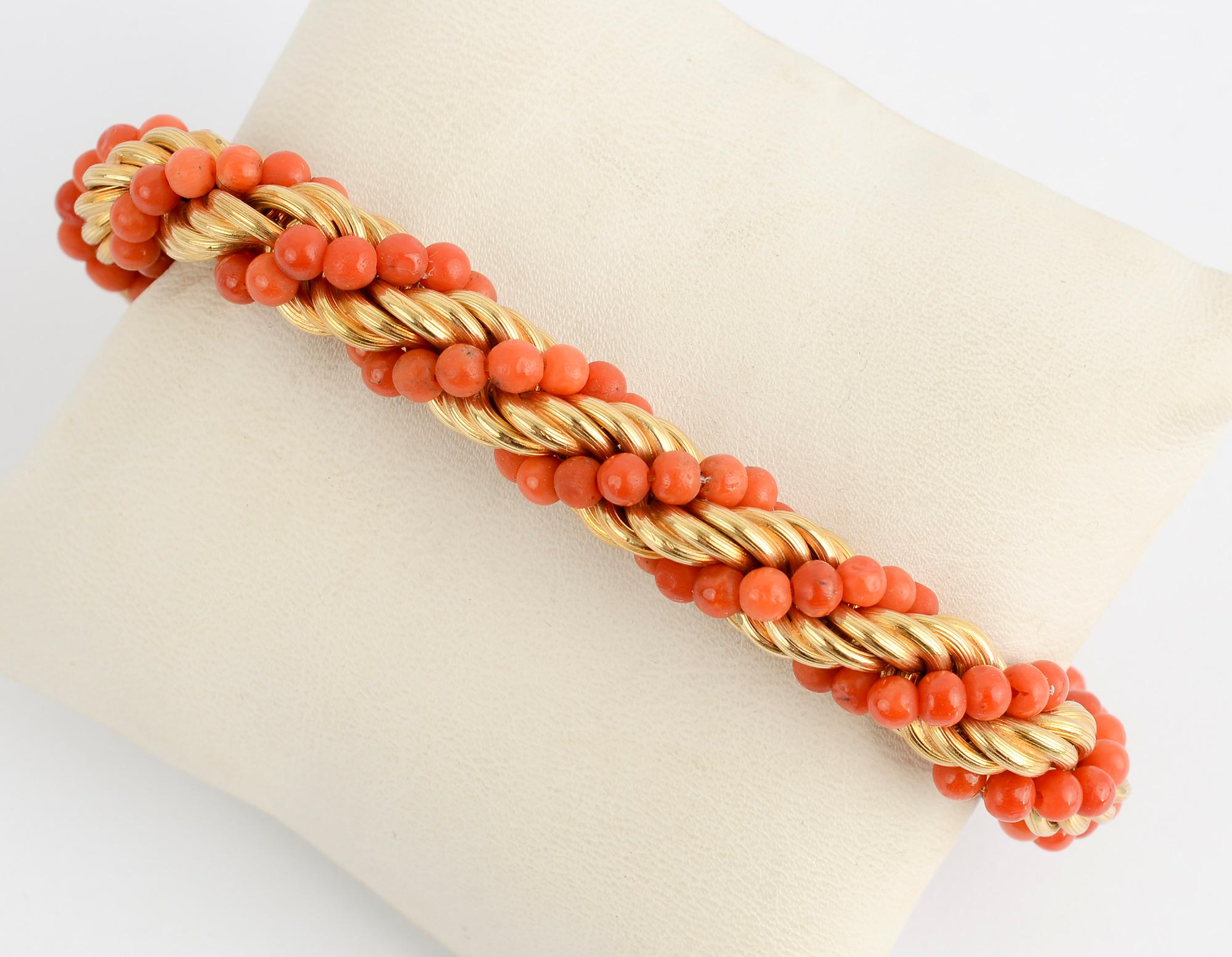 Classic rope twist bracelet by Van Cleef and Arpels. Bands of gold are combined with beautifully colored coral beads. Length is 8 3/16