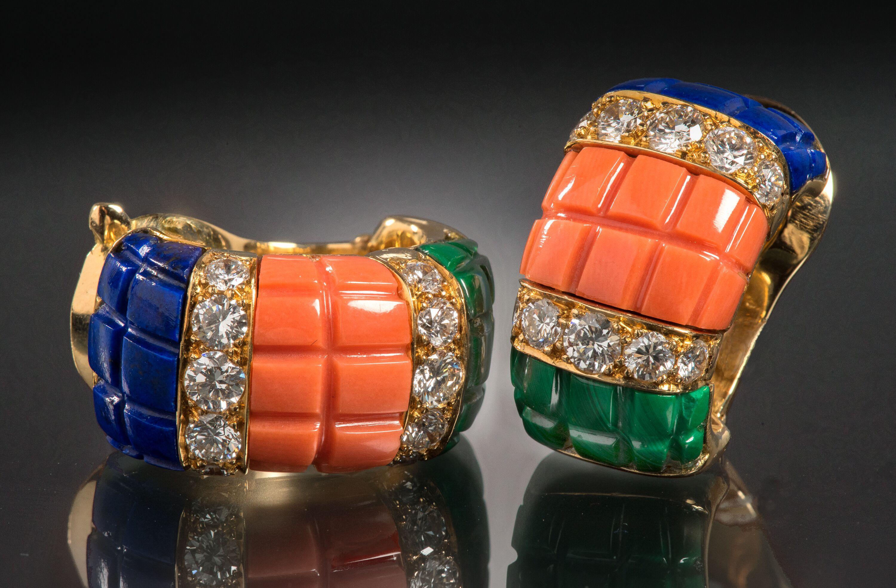 These ear clips demonstrate Van Cleef & Arpels’ mastery of materials. Deep shades of coral, malachite and lapis lazuli are accented by bright white diamonds set into 18k gold. 

Approximately 0.80 inches long
Signed VCA, numbered NY 8K605-75
Made in