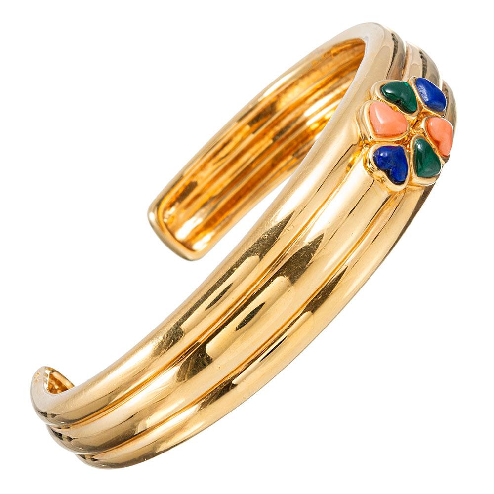 This sweet ribbed cuff of 18 karat yellow gold is accented with a cluster of heart-shaped natural stones at its center. Three-dimensional coral, malachite and lapis hearts are contained in golden bezels and lend a lovely color combination to the