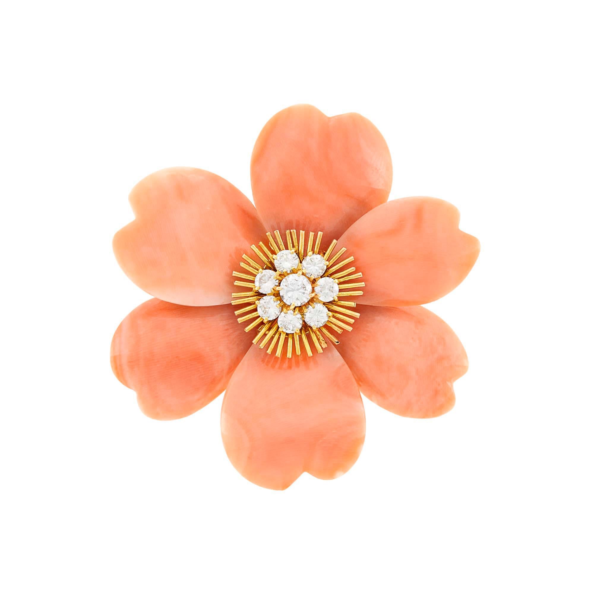 Van Cleef & Arpels Gold, Angel Skin Coral and Diamond 'Rose de Noel' Clip- Brooch, France This flower shaped pin has heart-shaped angel skin coral petals centering a floret of 8 round diamonds ap. 1.30 carats.  within polished radiating stamens all