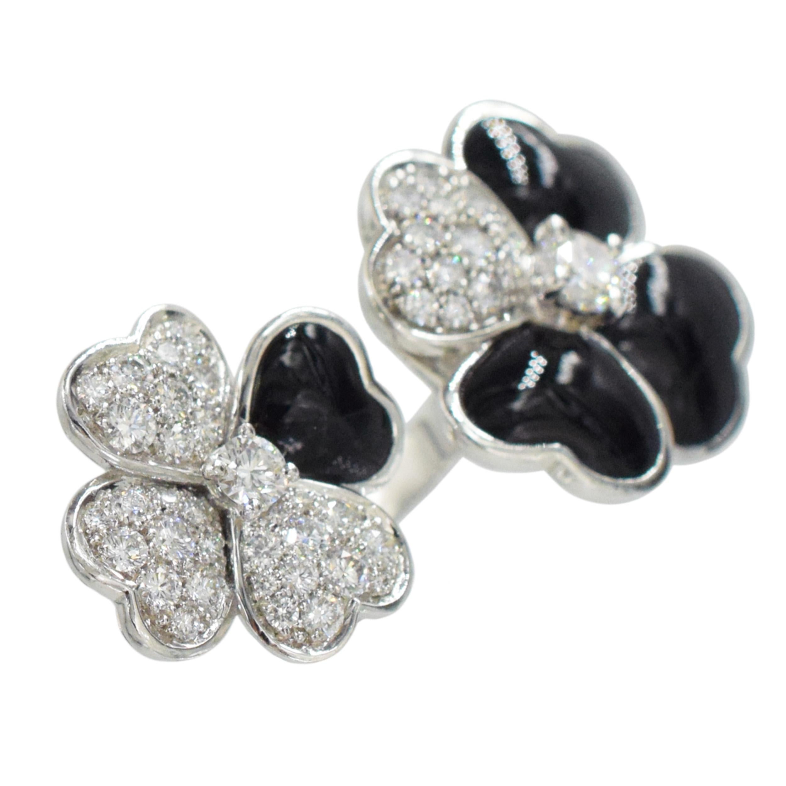 Van Cleef & Arpels Cosmos Between the Finger ring in white gold with brilliant-cut diamond buds surrounded by onyx and diamond petals.
  This ring is crafted of 18 karat white gold and features two flower motifs set with black onyx and round