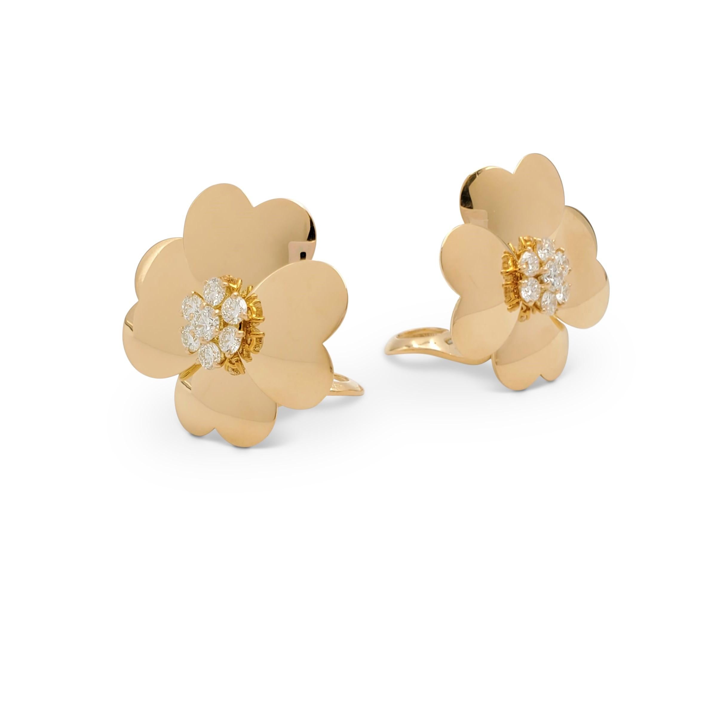 Authentic Van Cleef & Arpels earrings from the iconic 'Cosmos' collection. Designed as a pair of flowers composed of four heart-shaped petals crafted in 18 karat yellow gold. The centers are highlighted with round brilliant cut diamonds (E-F color,