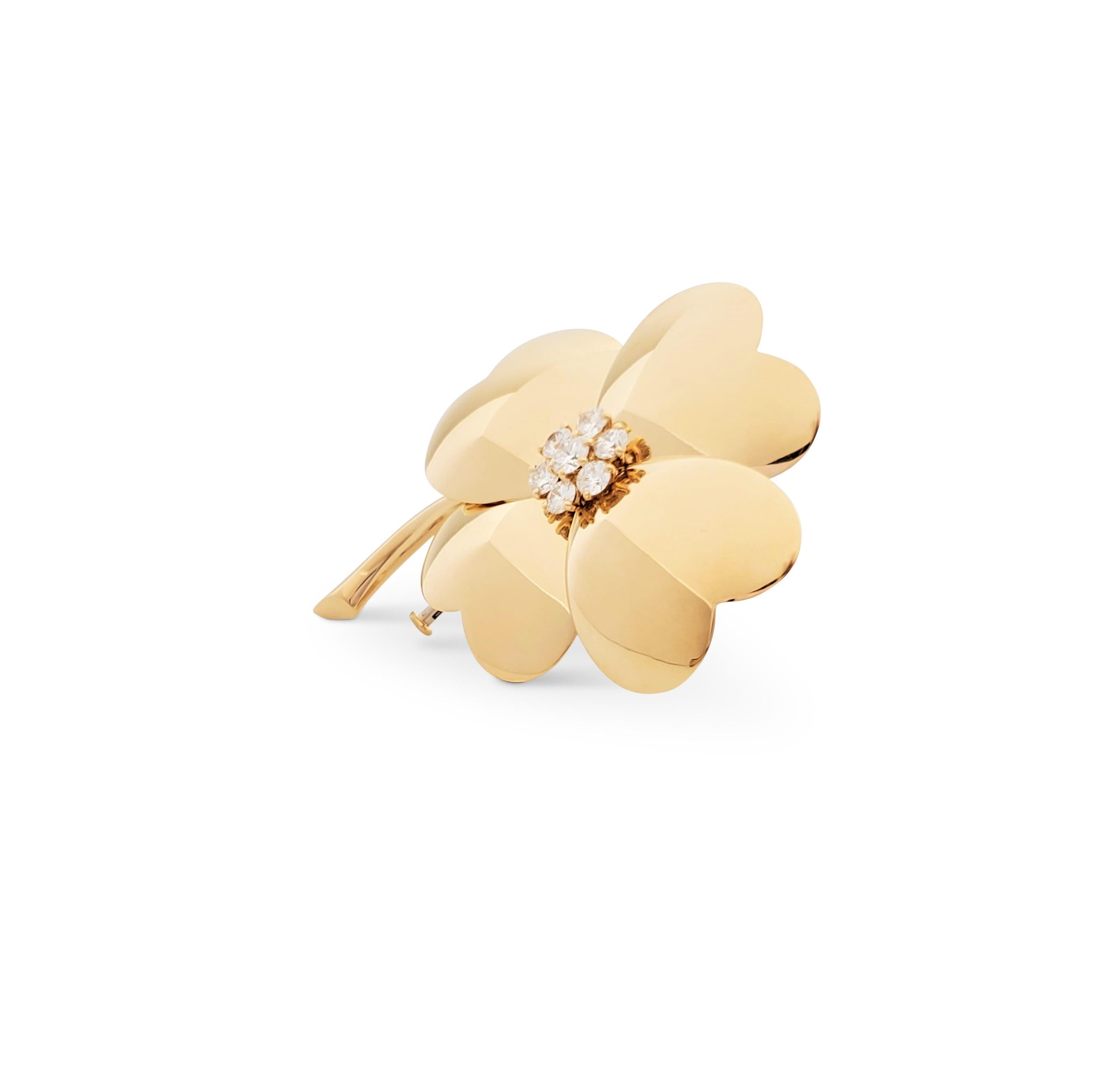 Authentic Van Cleef & Arpels pin from the iconic 'Cosmos' collection. Designed as a flower composed of four heart-shaped petals crafted in 18 karat yellow gold. The center is highlighted with round brilliant cut diamonds (E-F color, VS clarity)