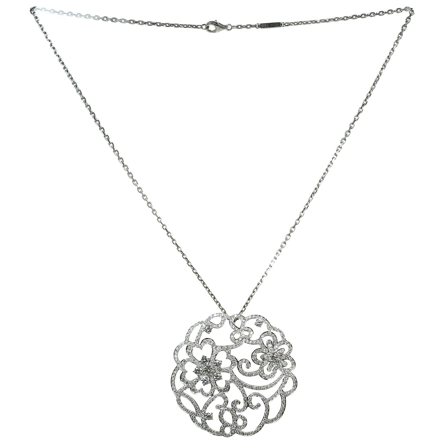 This exquisite Van Cleef & Arpels Dentelle collection necklace is crafted in 18k white gold and features a round open-work pendant set with brilliant-cut round D-F VVS1-VVS2 diamonds. Made in France circa 2000s. Measurements: 2.04