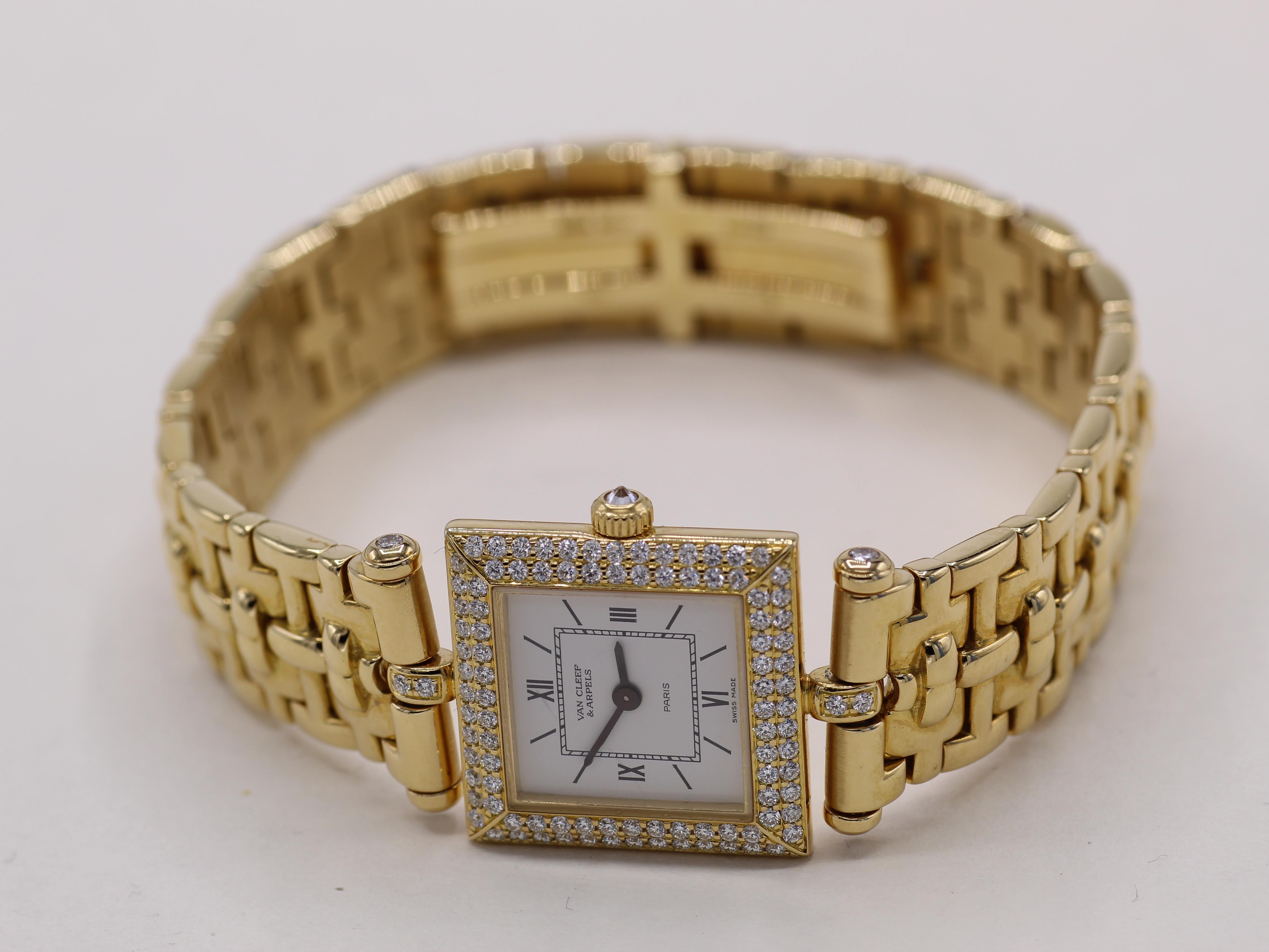 Van Cleef & Arpels 18 Karat gold ladies wristwatch with a quartz movement, square enamel dial with Roman numerals at 12,3,6 and 9. Bordered by a slanted bezel pave set with 2 rows of round brilliant cut diamond and an upside down bezel set diamond