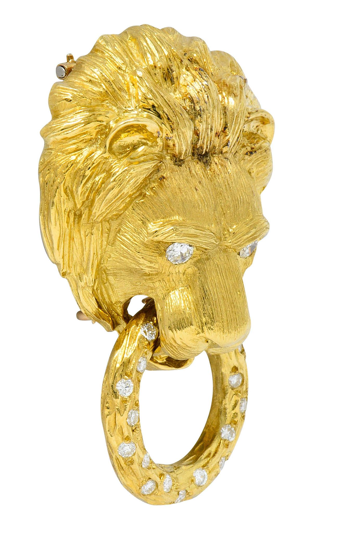 Doorknocker brooch is designed as a highly rendered lion face

Clutching a textured and articulated ring in its jaws

Eyes and ring are set with round brilliant cut diamonds

Weighing approximately 1.05 carats with F/G color and VS