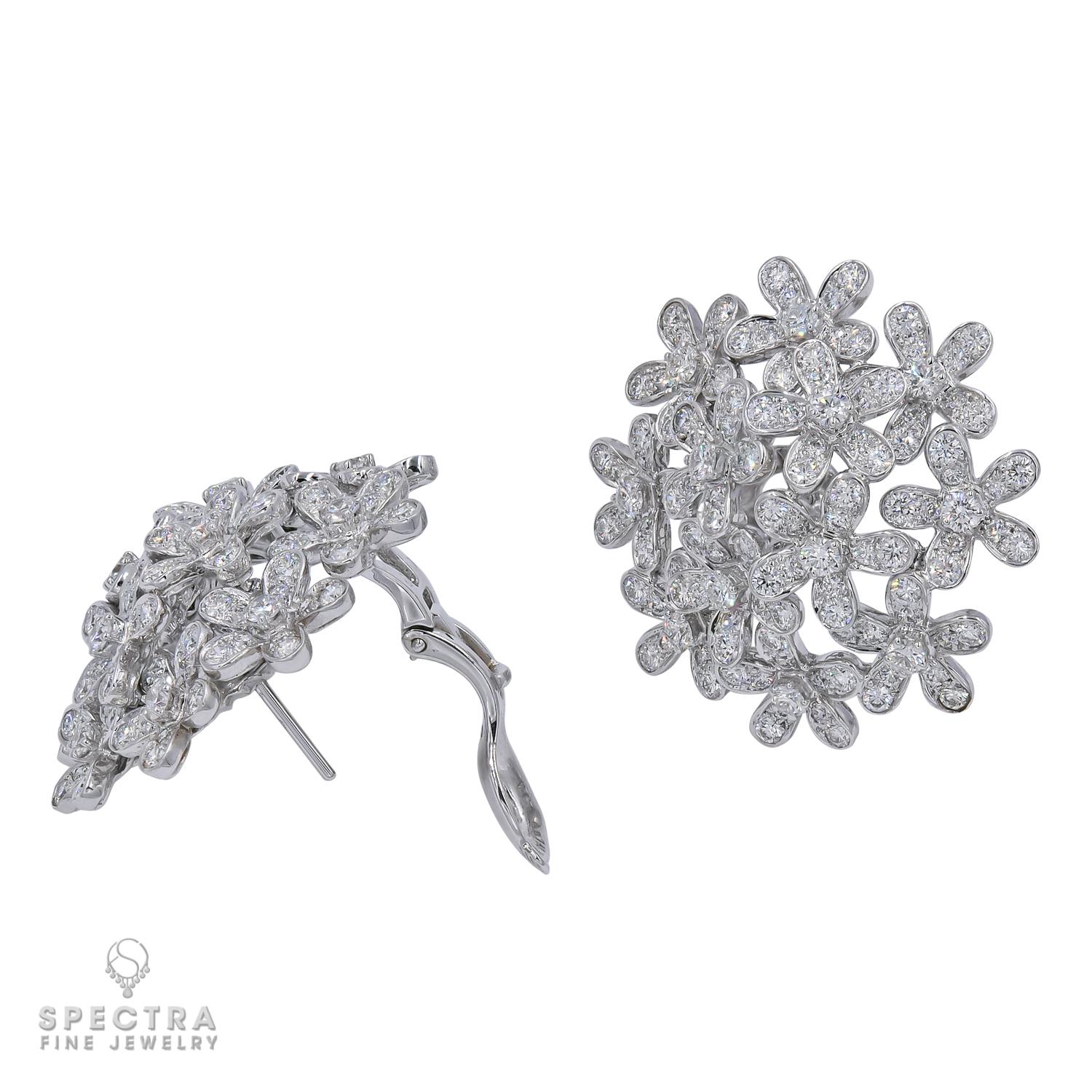 This striking Van Cleef & Arpels pair of pierced earrings with French clips from the celebrated Socrate™ jewelry collection feature a delicate floral motif crafted in 18K white gold and set with approximately 265 brilliant-cut round diamonds