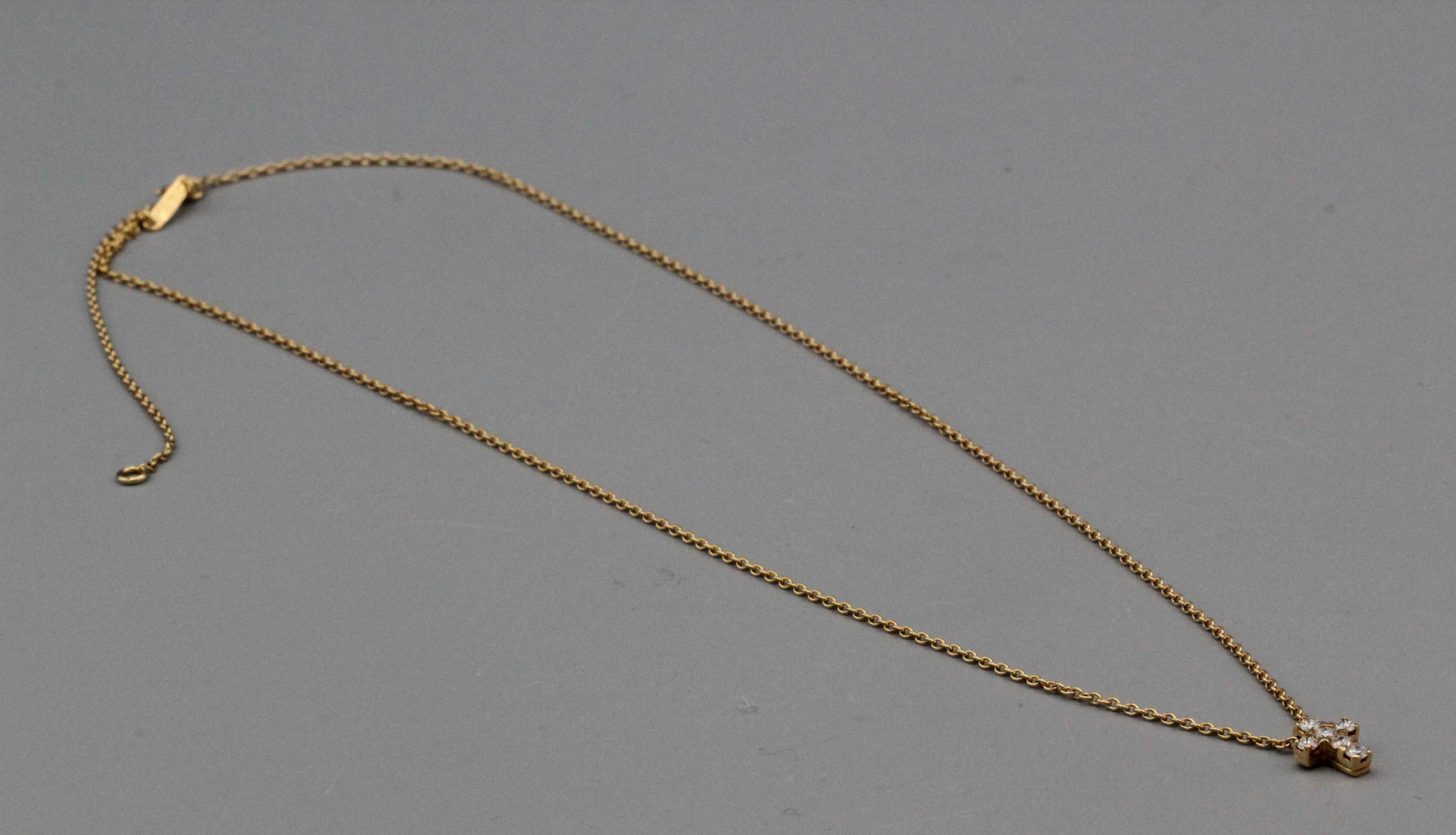 The petite diamond and 18k gold cross necklace by Van Cleef & Arpels is a beautiful piece of jewelry that exudes elegance and sophistication. Crafted from the finest materials, this necklace features a delicate 18k gold chain that is expertly