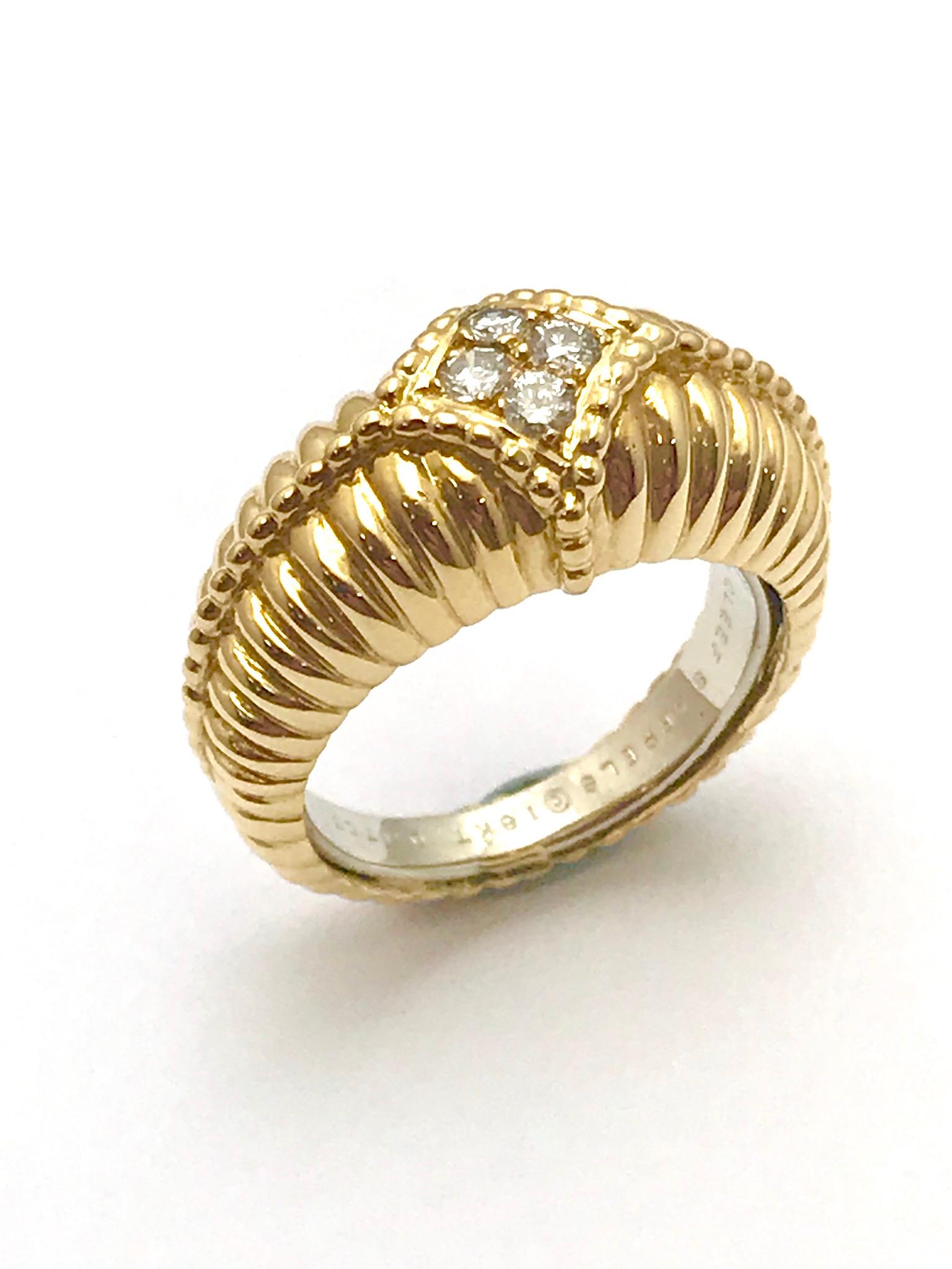 A Van Cleef & Arpels diamond and 18 karat yellow gold ring.  the ring is designed in a scalloped pattern with four diamonds in the framed in the center.  The diamonds are round brilliant cuts, graded as E-F color, VVS clarity, having a total weight