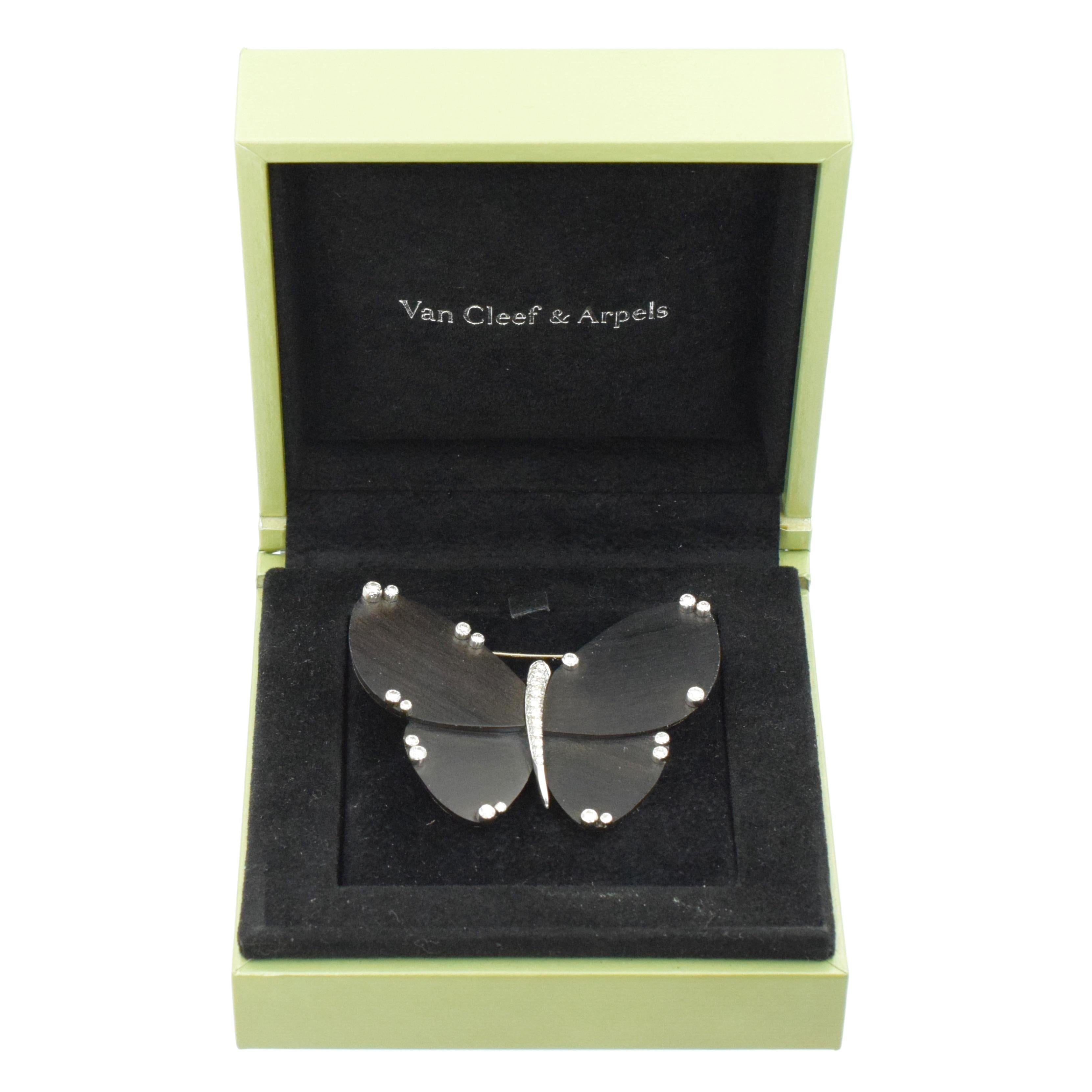 
Van Cleef & Arpels diamond and ebony wood brooch in 18k white gold. The wings made of ebony wood panels, accented by scattered around the edges bezel set round brilliant cut diamonds and pave set with round brilliant cut diamonds body. 
Signed: VCA