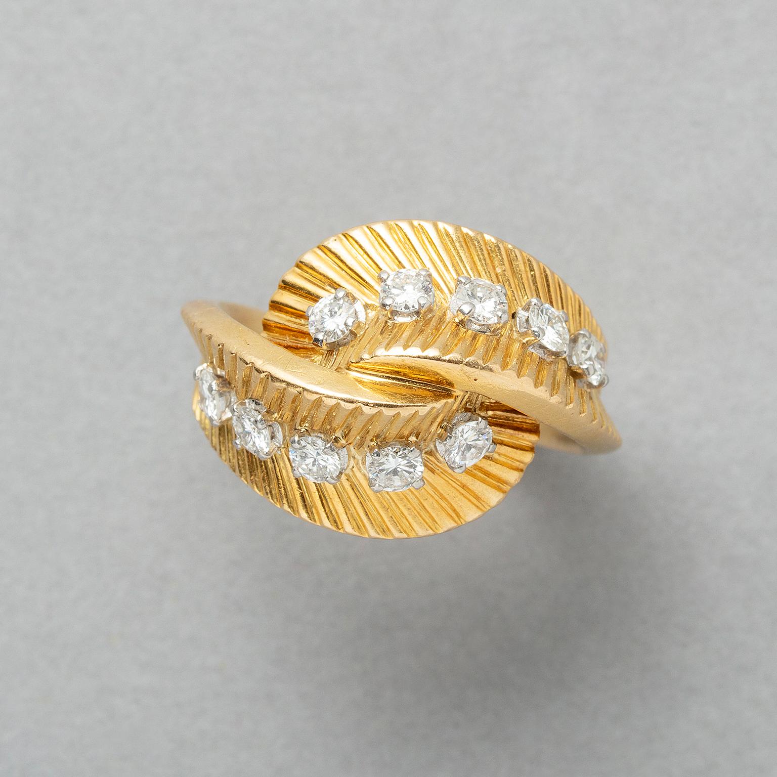 A mid-Century 18k gold ruby and diamond bombe bypass ring by Van Cleef & Arpels. This pretty fluted ring is set with 10 round brilliant cut diamonds weighing 0.65 cts in total. The stones are set within fluted curved gold that wraps around each