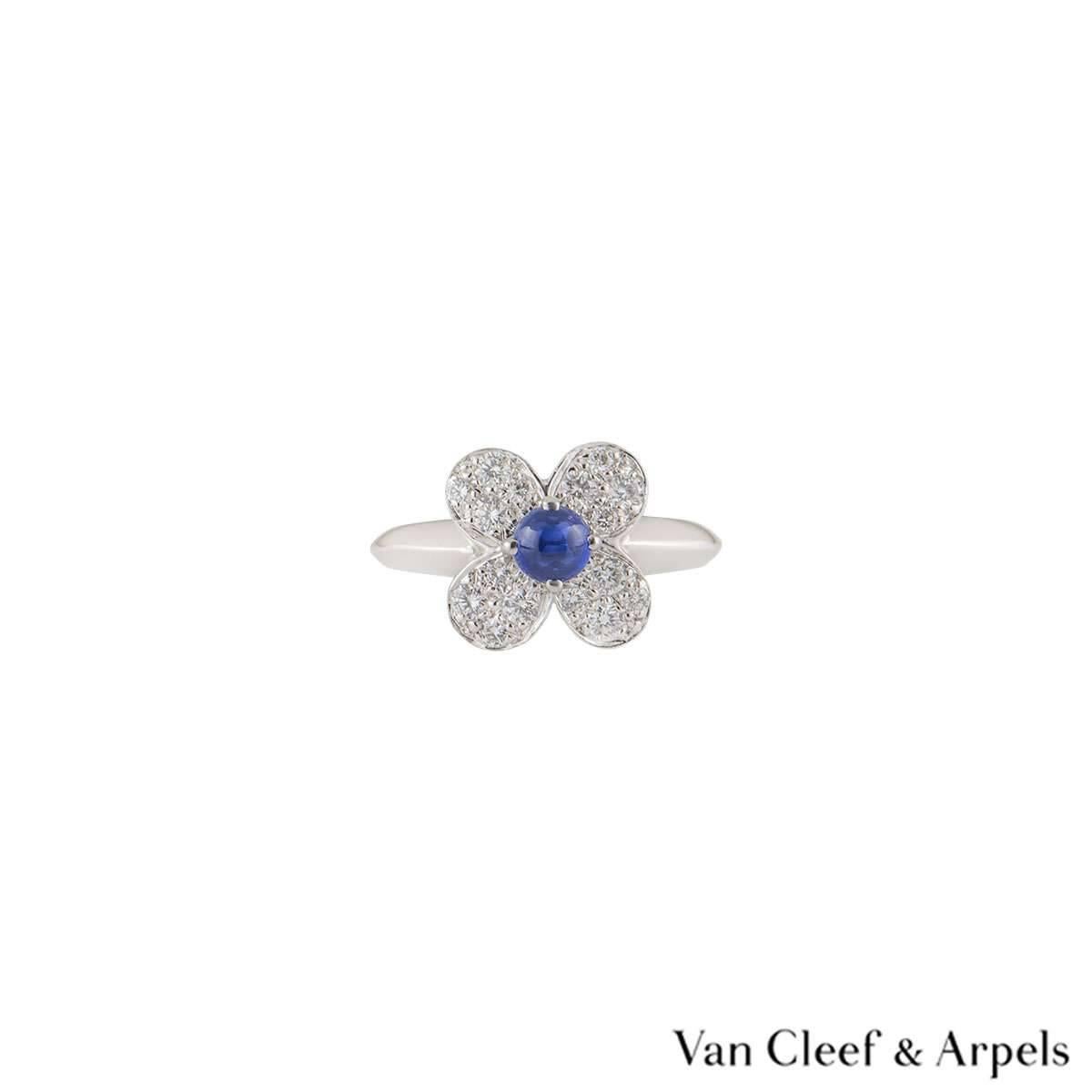 A beautiful 18k white gold Van Cleef & Arpels diamond ring from the Alhambra collection. The central flower motif is set with a single claw set blue cabochon cut sapphire. The surrounding petals of the flower are pave set with round brilliant cut