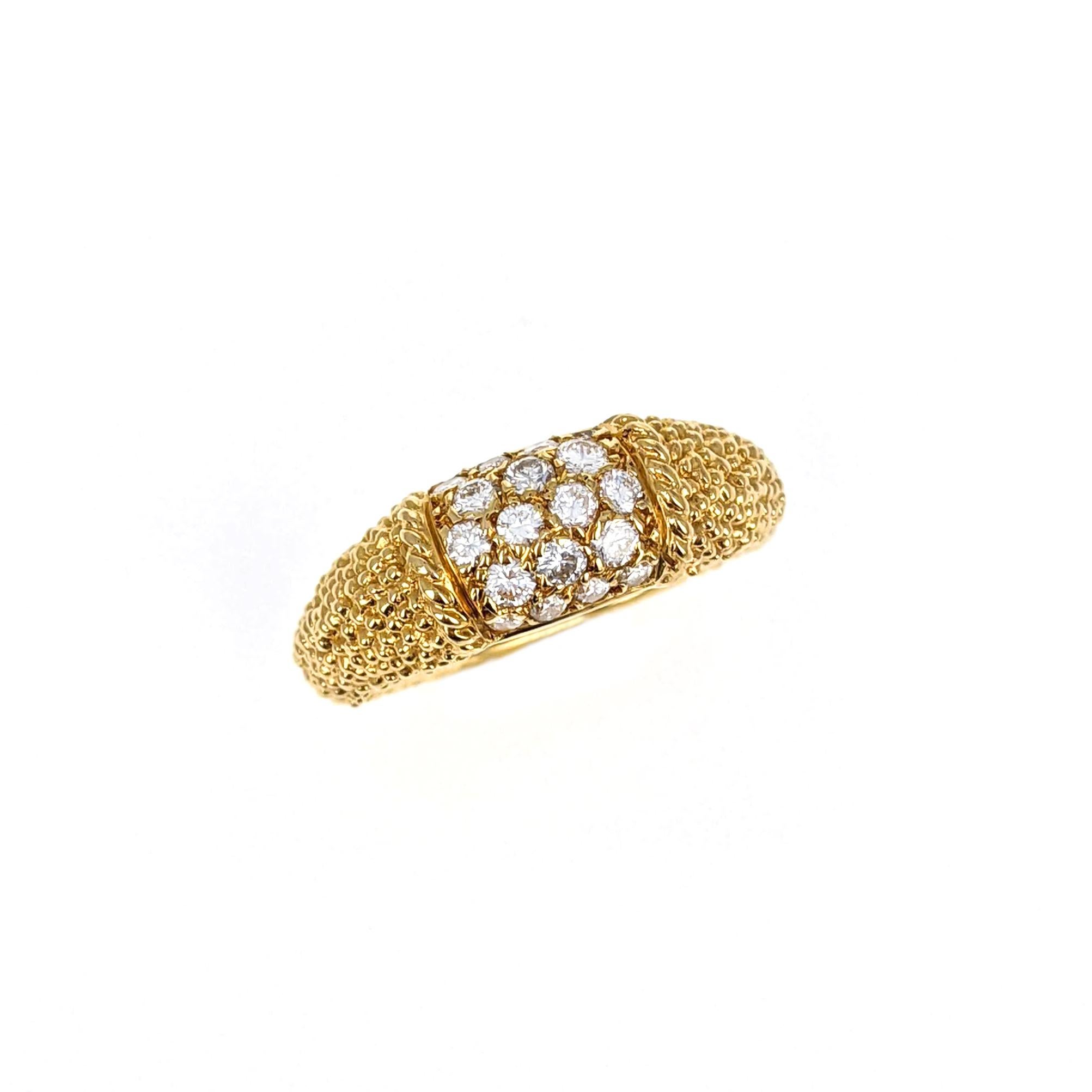 This classic Philippine ring from Van Cleef and Arpels features a center section with round diamonds weighing approximately .5 carats. The textured band is made of 18 karat yellow gold. The piece is signed with partial maker's mark, numbered, and