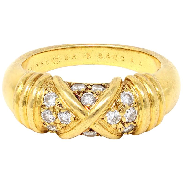A signed Van Cleef & Arpels Diamond band ring in 18K yellow gold. Made in France during the 1990s, this signed Van Cleef & Arpels band ring features full-cut round Diamonds with a total weight of 0.28 carats and F color and VVS- VS clarity, divided