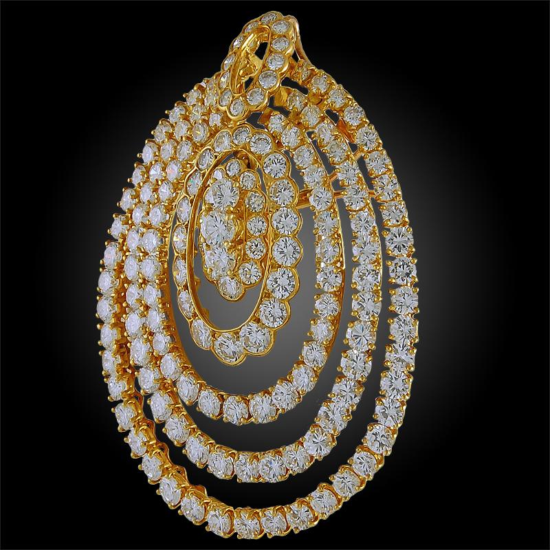 A remarkable brooch pendant by Van Cleef & Arpels that dates back to the 1980s, comprised of 18k yellow gold set with 20 carats of brilliant round cut diamonds forming rows of circular motifs within one another.
FRENCH
SIGNED- VCA