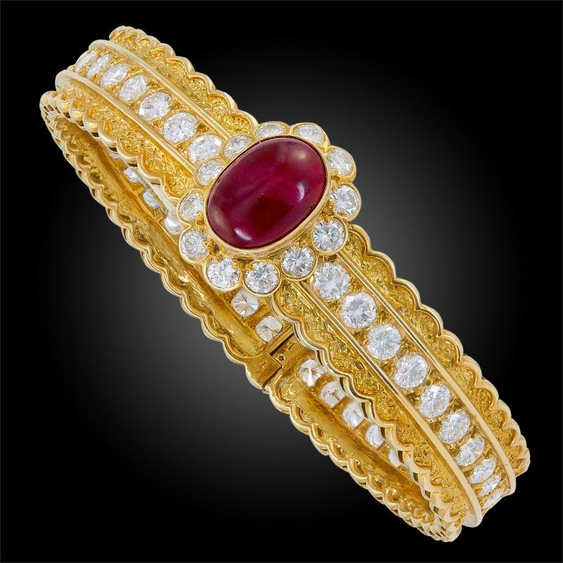An 18k yellow gold bangle bracelet, set with brilliant-cut diamonds and cabochon ruby, signed Van Cleef & Arpels.

Inner circumference is approx. 160mm
Made in France