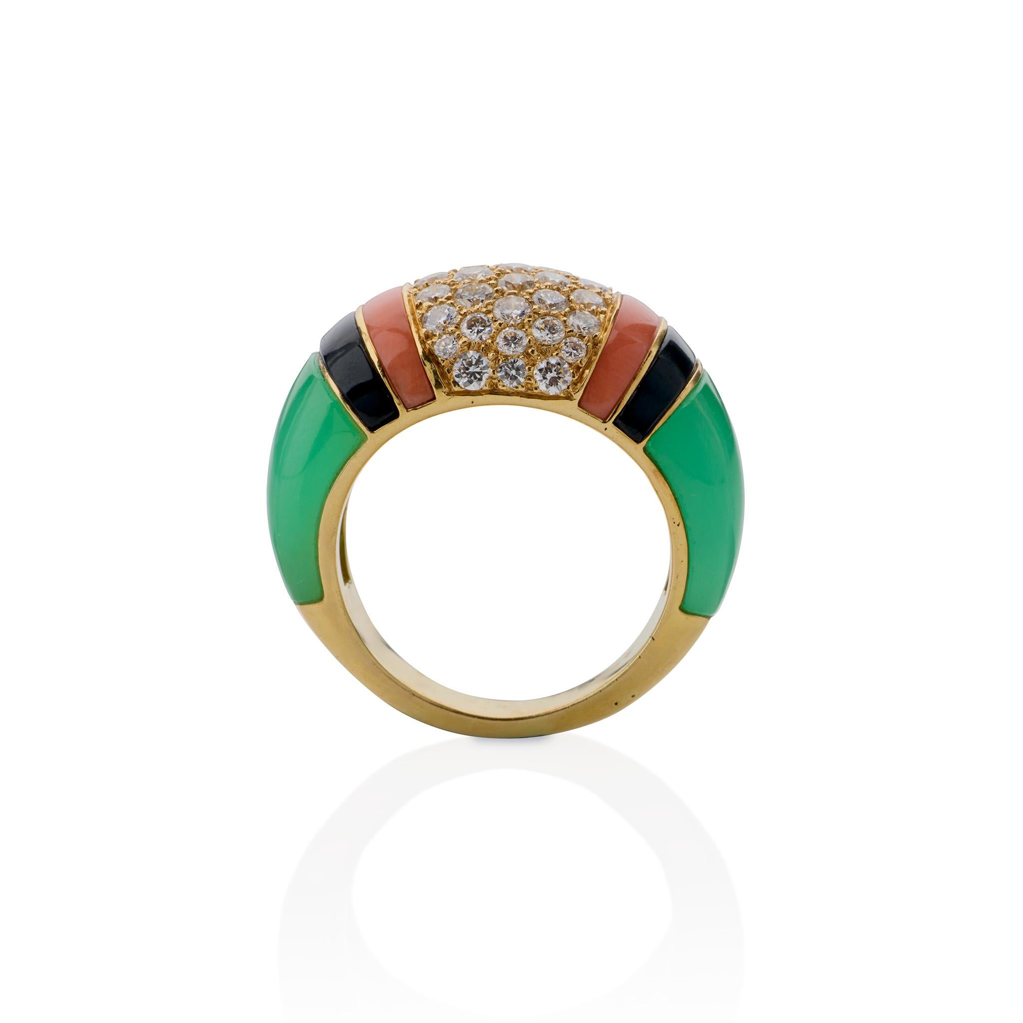 Designed in the late 1980s, this diamond, chrysoprase, coral and onyx ring was made by Van Cleef & Arpels, Paris. The ring centers a field of pavé-set round brilliant-cut diamonds flanked by coral, onyx and chrysoprase sections. With its crisp