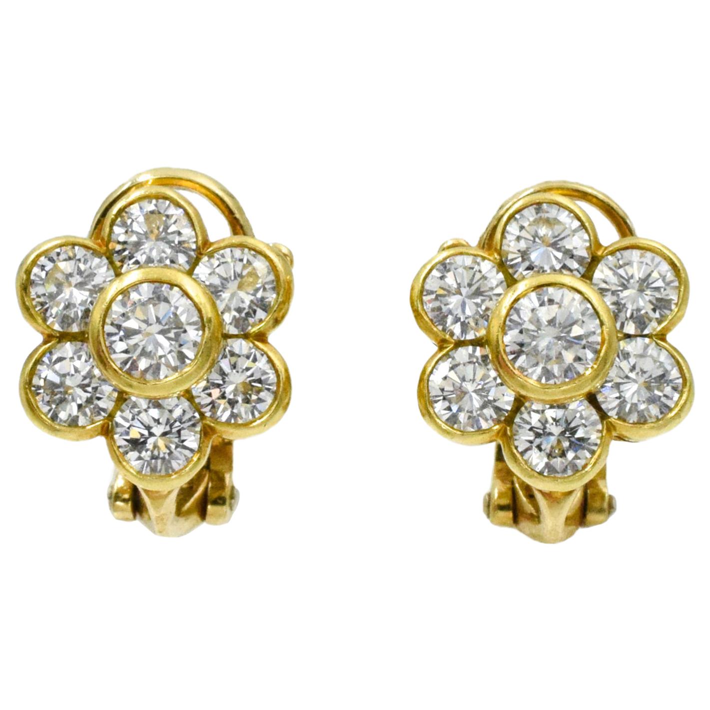 Van Cleef and Arpels Diamond Flower Earrings. This pair of earrings has 14 roound diamonds with a total carat weight of approximately 2.6 carats all bezel set in 18k yellow gold with omega back.
 Signed Van Cleef & Arpels Serial No. NY xxxxx,
