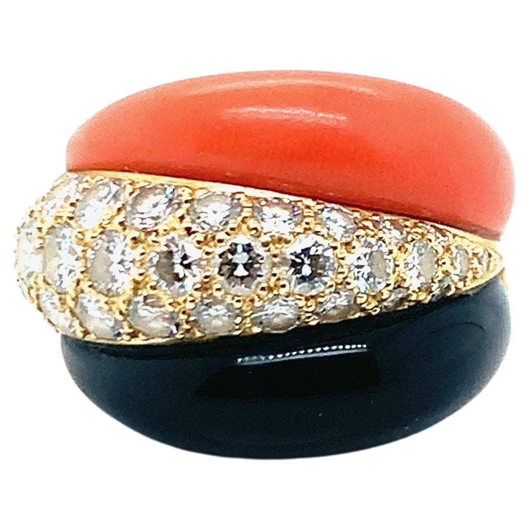 An 18 karat yellow gold Van Cleef & Arpels ring, featuring a 1.44 carat diamond, coral, and onyx. Signed VCA. Total weight: 10.8 grams. Ring size: 6.25.

Serial No. B51261121