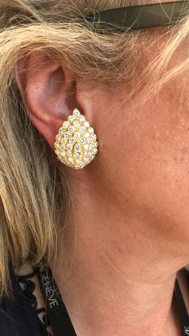 Comprising a pair of Van Cleef & Arpels earrings designed as pear shaped motifs, set with an opulence of brilliant- cut diamonds throughout, finely crafted in 18k yellow gold, signed Van Cleef & Arpels.