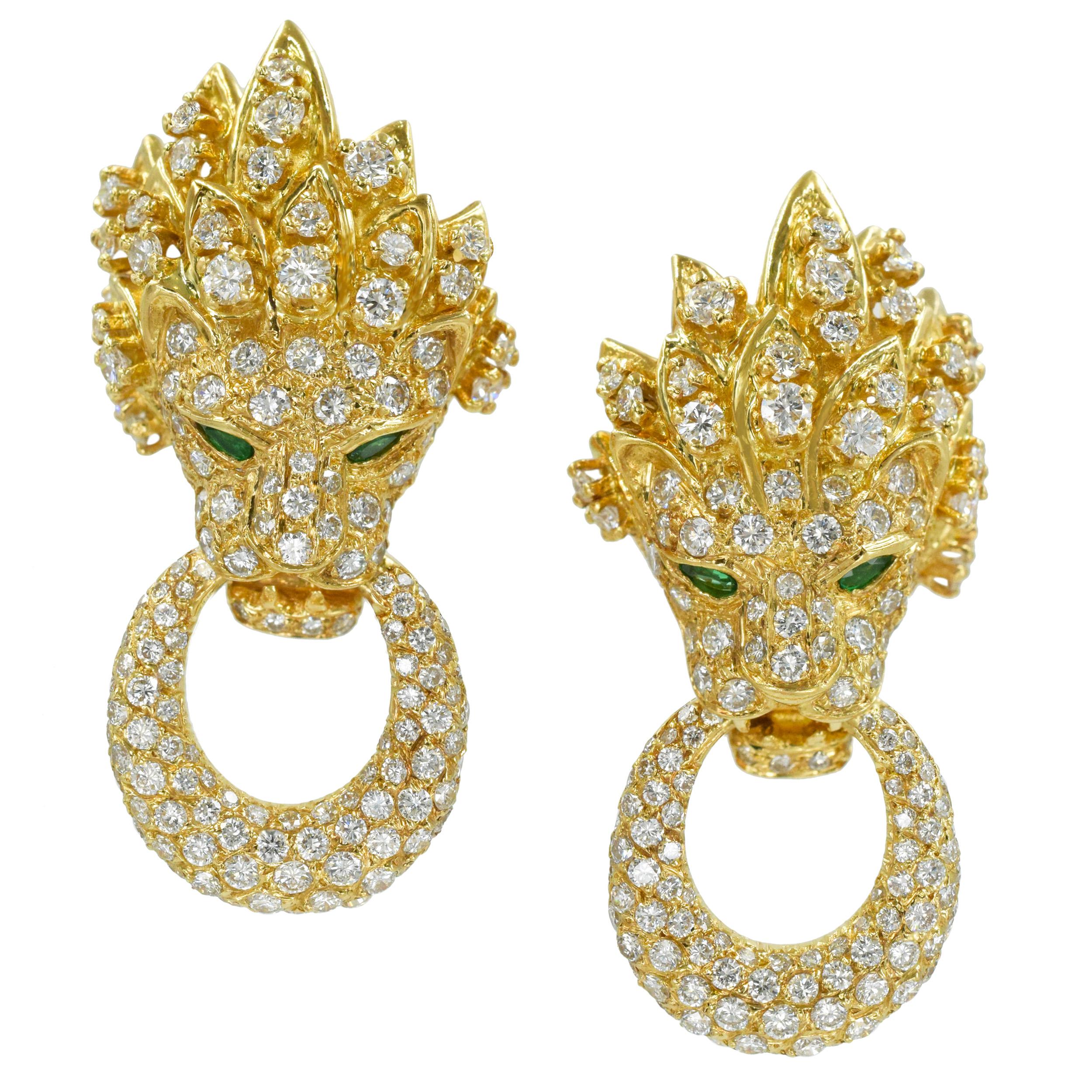 Vintage Van Cleef & Arpels 18k yellow gold, diamond and emerald doorknocker ear clips.
The earrings feature head of the lion holding a large ring in his mouth, both encrusted with diamonds, accented with emerald eyes. 
The earrings are set with 308