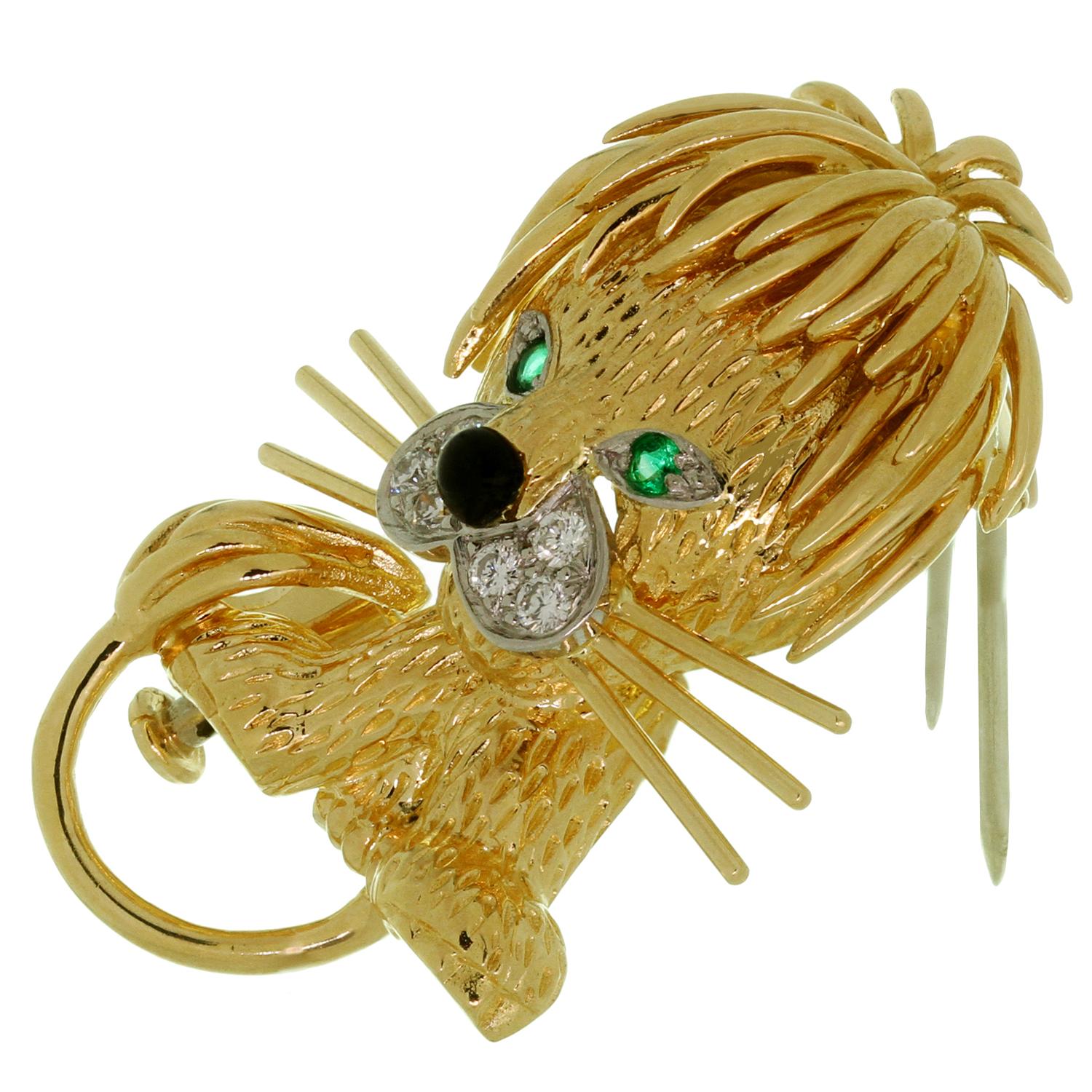 This iconic Van Cleef & Arpels brooch features a stunning lion design crafted in 18k yellow gold and accented with faceted emerald eyes, black enamel nose and brilliant-cut round E-F VVS2-VS1 diamonds of an estimated 0.15 carats. Made in France