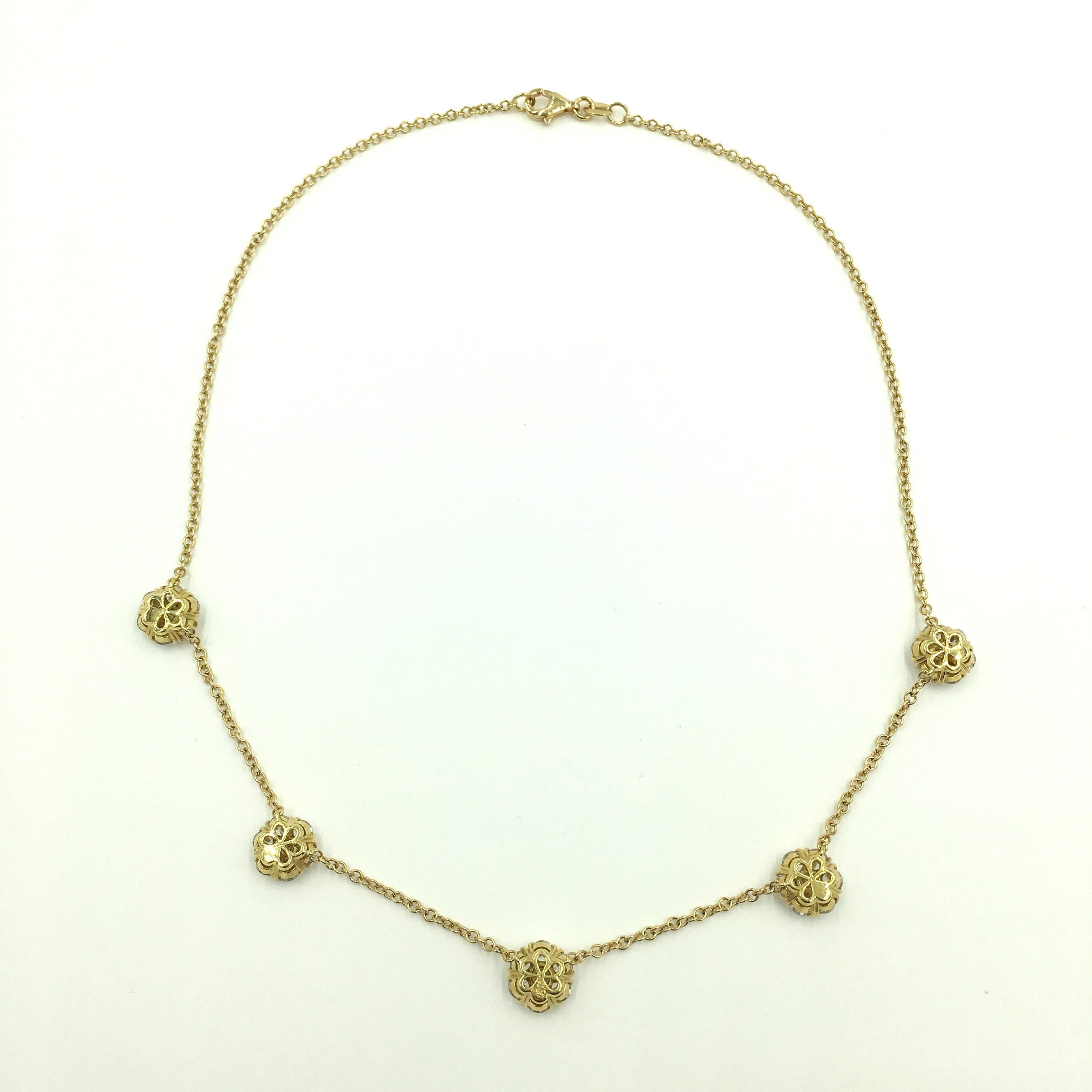 An 18 karat yellow gold and diamond large Fleurette necklace. Van Cleef & Arpels. Designed as a fine link chain, set with five (5) circular cut diamond flouretts, Thirty five diamonds weigh approximately 4.70 carats. Length is approximately 16
