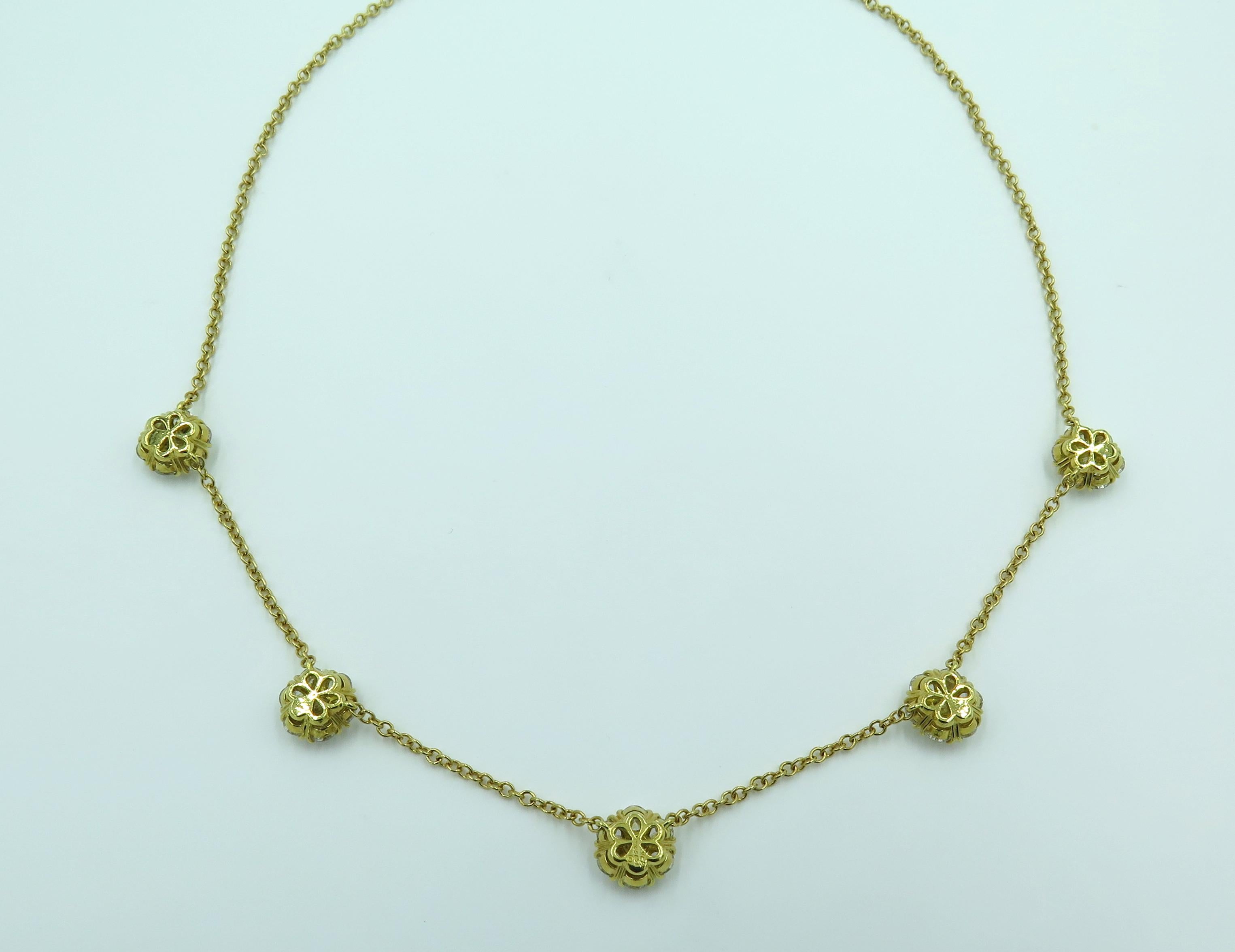 An 18 karat yellow gold and diamond large Fleurette necklace. Van Cleef & Arpels. Designed as a fine link chain, set with five (5) circular cut diamond fleurettes. Thirty five diamonds weigh approximately 4.70 carats. Length is approximately 16