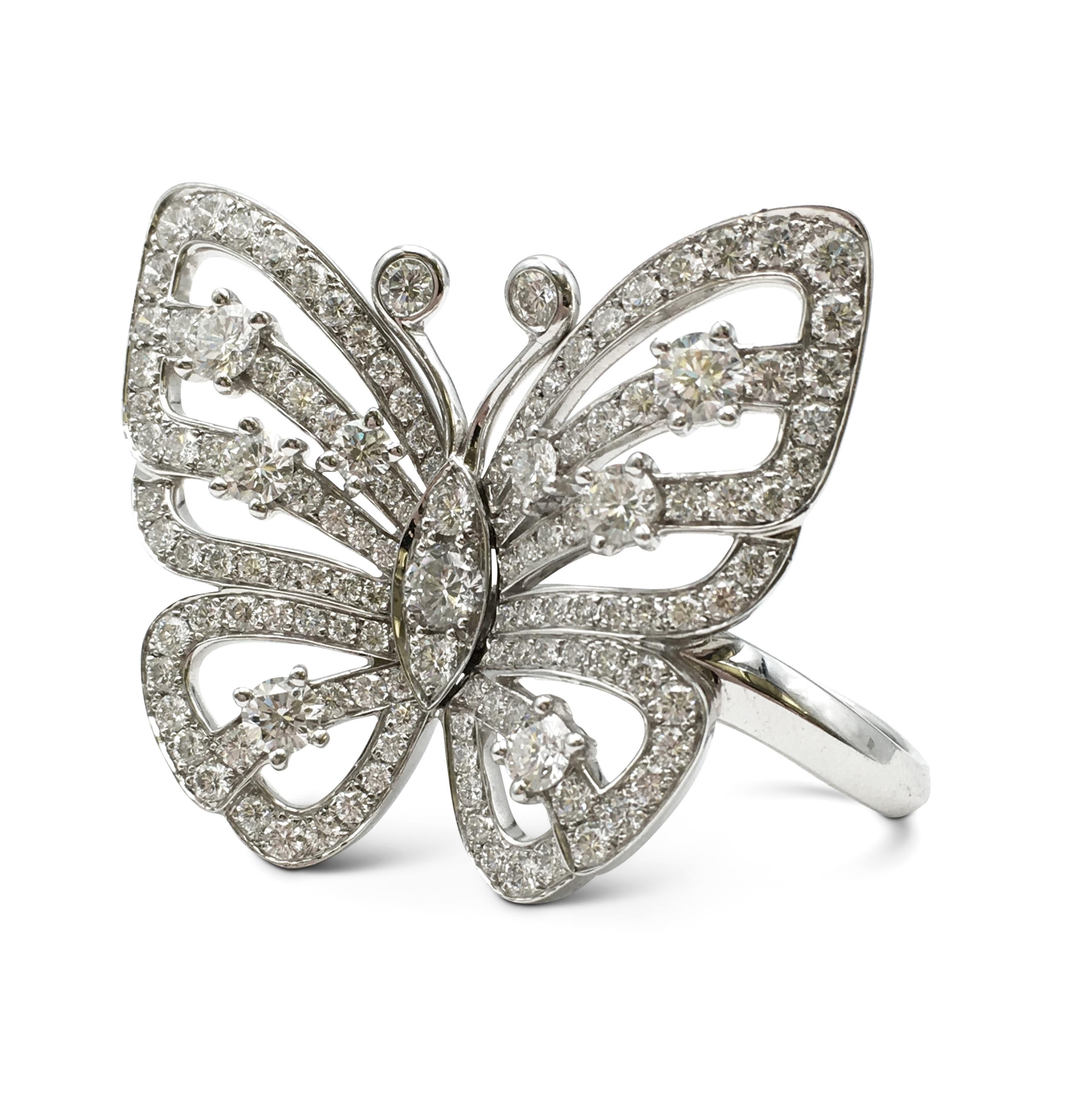 Authentic Van Cleef & Arpels 'Flying Butterfly' ring crafted in 18 karat white gold features an openwork design set with an estimated 3.11 carats of high-quality round brilliant cut diamonds. The between-finger style ring measures 33mm in width by