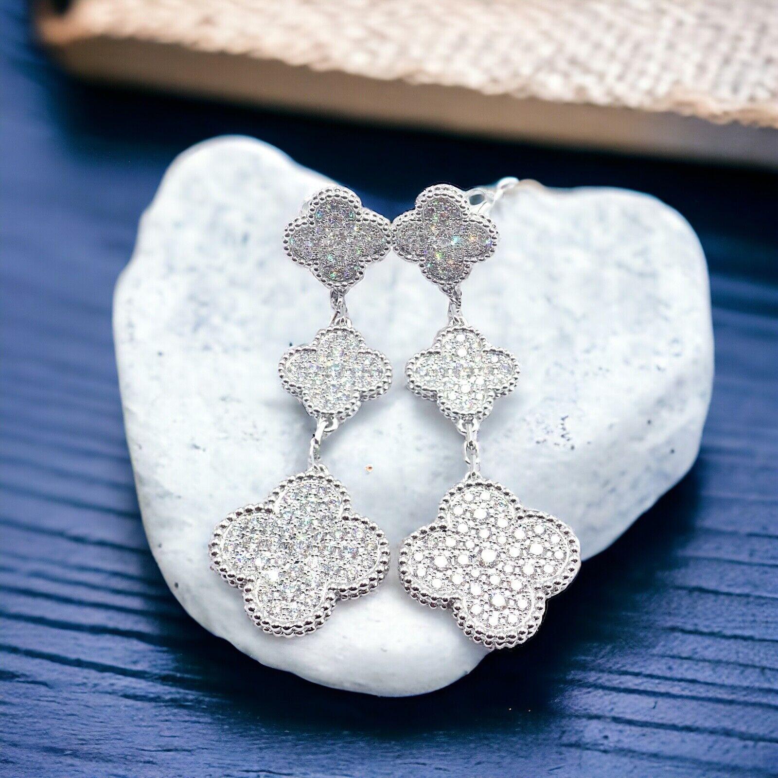 18k White Gold Diamond Magic Alhambra 3 Motifs Long Earrings by Van Cleef & Arpels.
The Van Cleef & Arpels 18k White Gold Diamond Magic Alhambra 3 Motifs Earrings are an exquisite piece of luxury jewelry. 
Each earring features three clover-shaped