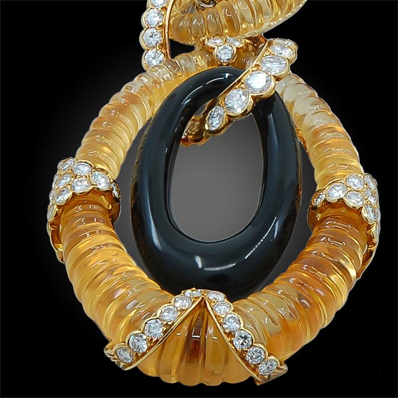 A stylish long link necklace convertible to bracelets by Van Cleef and Arpels dating back to the 1970s, centering a large pendant set with a fluted citrine surrounding an onyx hoop, embellished with brilliant-cut diamond accents, to the interlinked