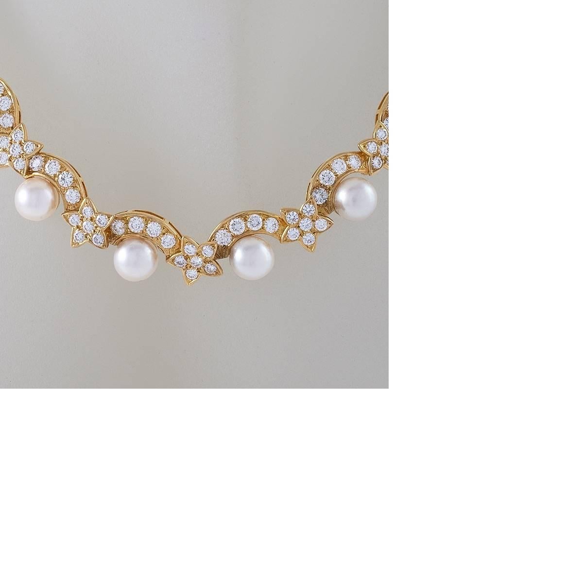 This joyfully-stylized pearl and diamond collar necklace by Van Cleef & Arpels is an exuberant depiction stars shooting over the moon. The polished gold hinged frame is set with over two hundred diamonds, punctuated with creamy white cultured