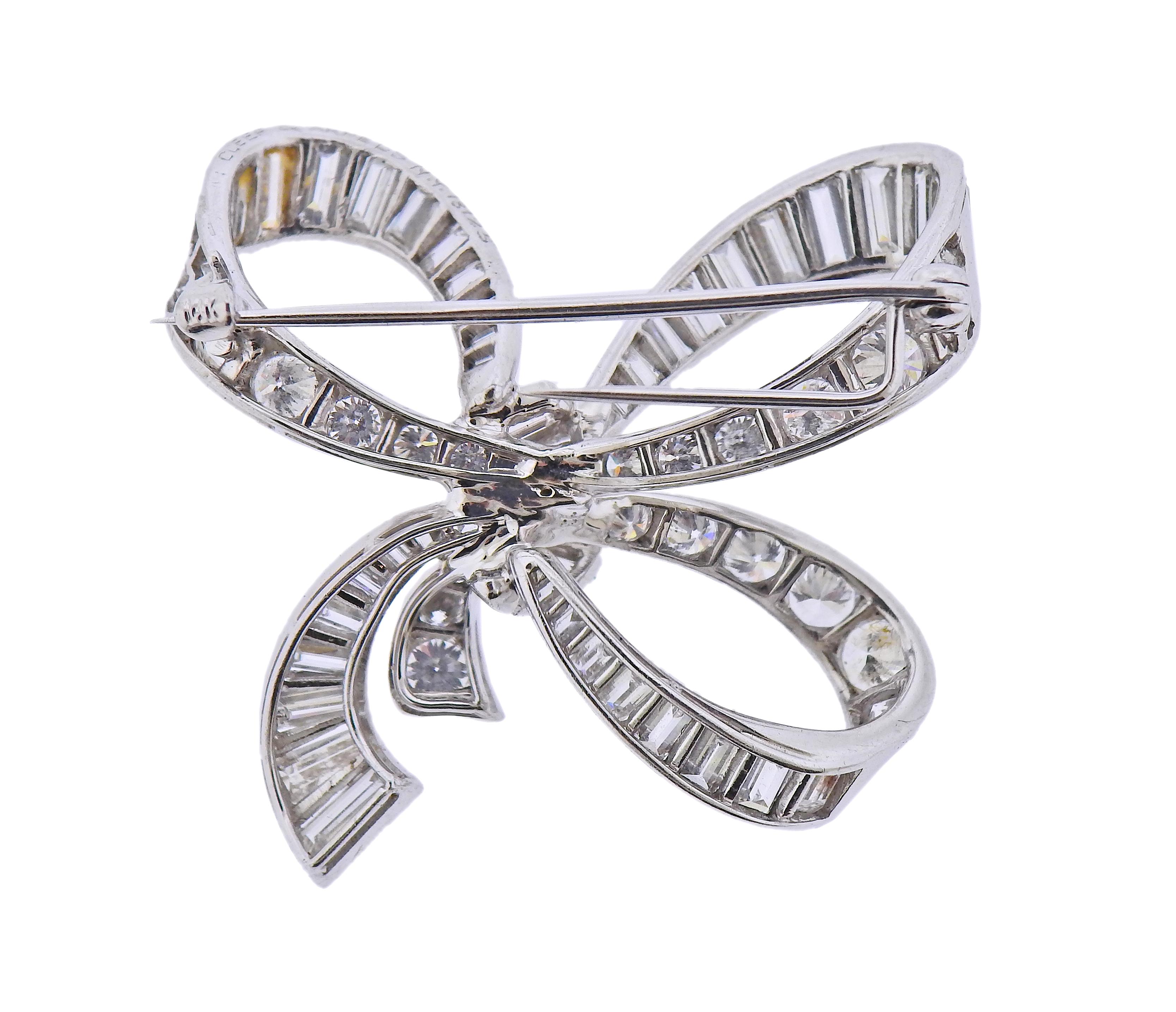 Van Cleef & Arpels platinum bow brooch, adorned with approximately 6 carats in baguette and round brilliant diamonds. Brooch is 35mm x 38mm. Marked: Van Cleef & Arpels N.Y, 18125. Weight - 15 grams.