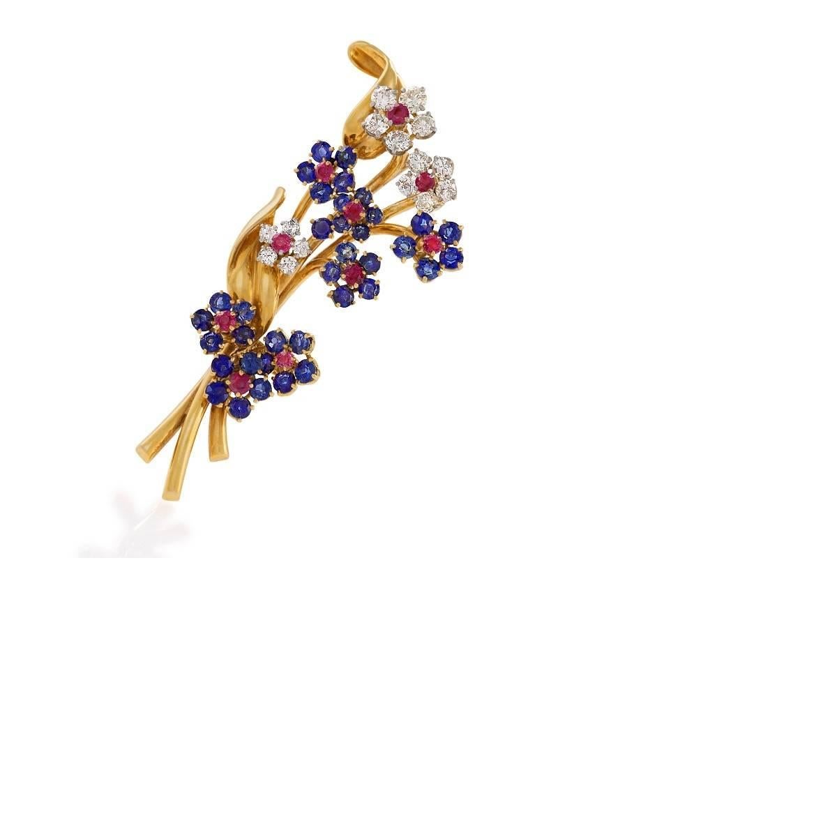 A Mid-20th Century 18 karat gold 'Hawaii' brooch with diamonds, rubies and sapphires by Van Cleef & Arpels. The brooch has 15 round diamonds with an approximate total weight of 1.35 carats, 10 round rubies with an approximate total weight of 1.00