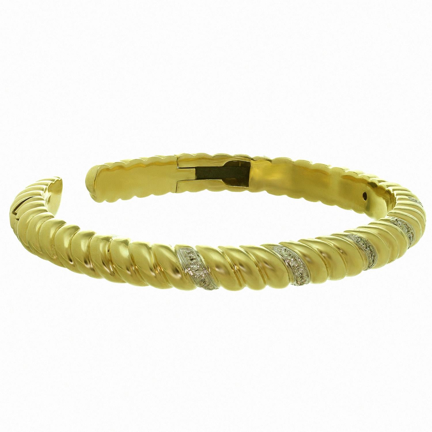 This classic vintage Van Cleef & Arpels hinged cuff bangle bracelet is crafted in 18k yellow gold and accented with brilliant-cut round G-H VS1-VS2 diamonds of an estimated 0.70 carats, set in white gold. Circa 1970s. Measurements: 0.23