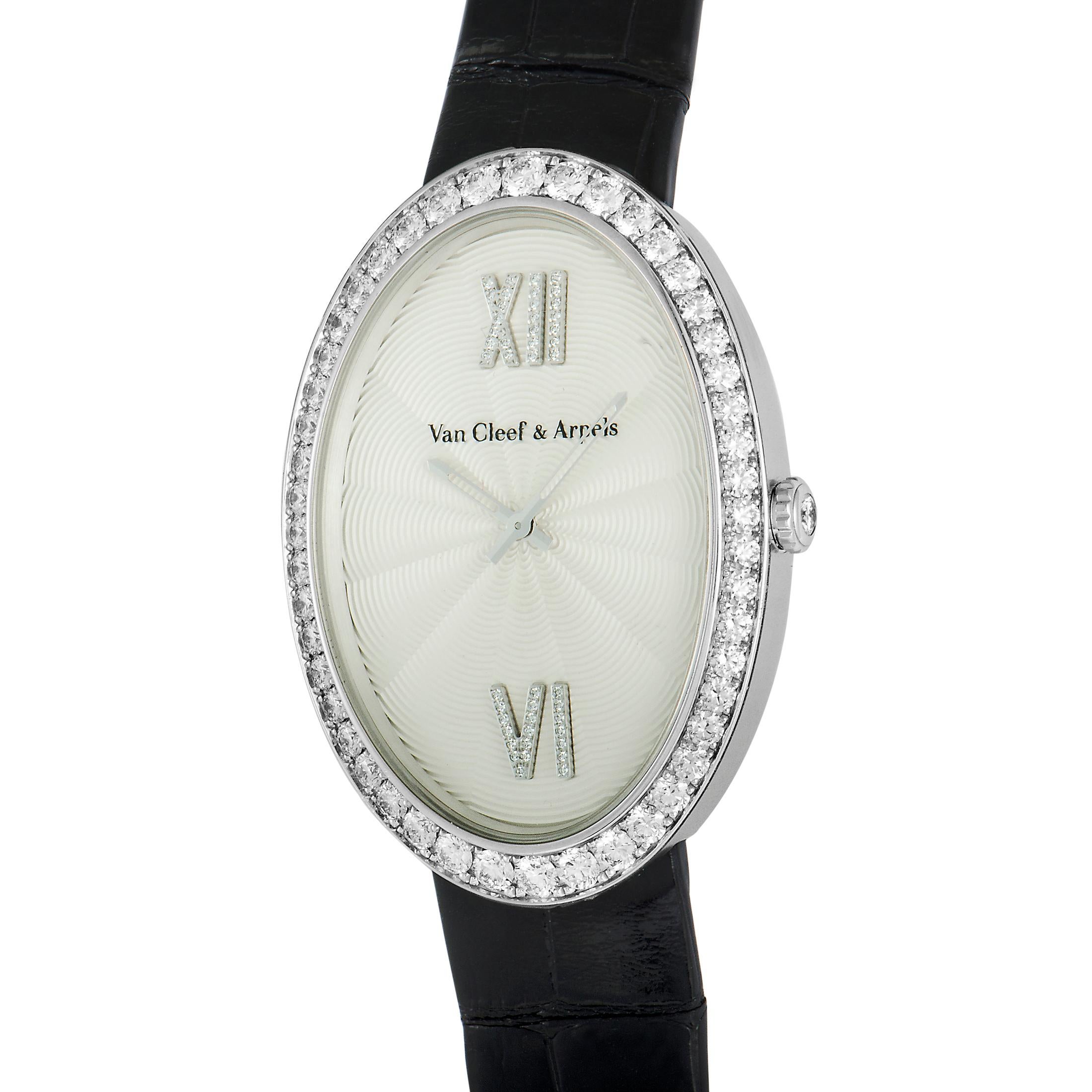 This Van Cleef & Arpels watch comes with a diamond-set 18K white gold case that is presented on a black leather strap, secured on the wrist with a diamond-set tang buckle. The dial features central hours and minutes, and boasts diamond-set Roman VI