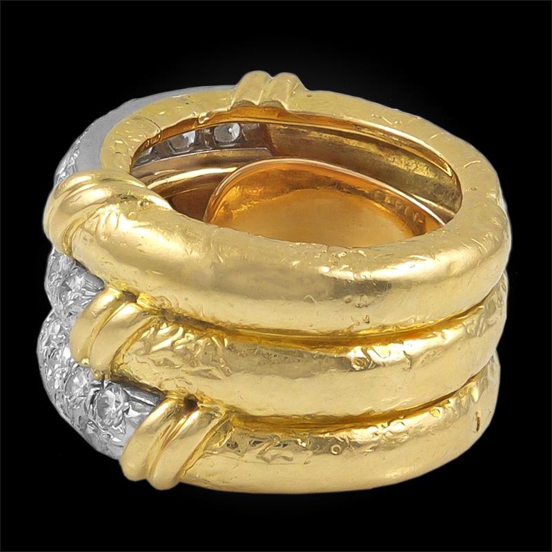 Bague éternelle de Van Cleef & Arpels, fabriquée en France dans les années 1970. Exceptionnellement réalisée en or jaune 18k, elle présente une triple couche de bandes d'or accentuée de diamants brillants sertis en pavé au centre. Bague taille