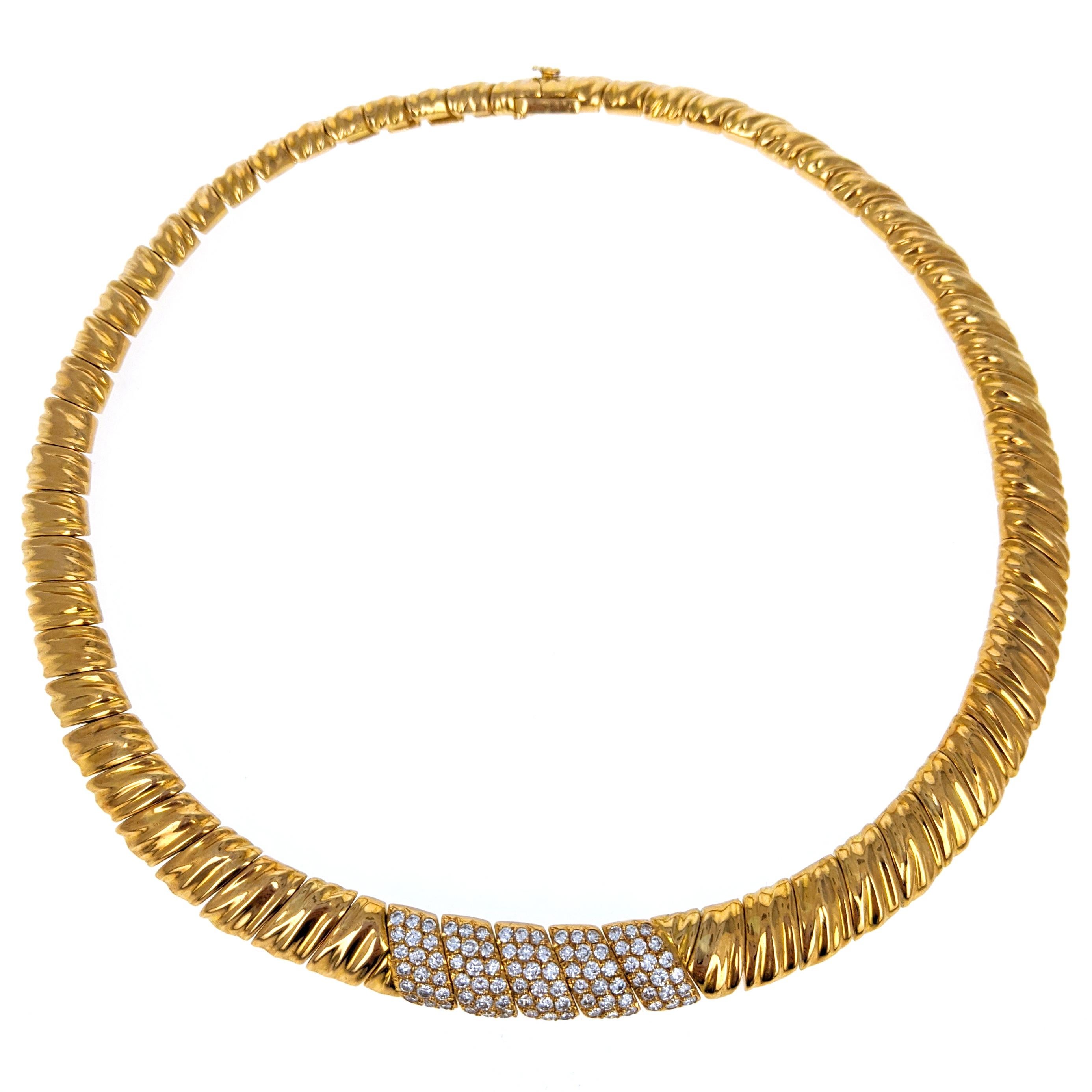 This choker necklace by Van Cleef & Arpels is comprised of 18 karat yellow gold textured links centering upon five pave-set diamond links. The diamonds are VS clarity, G-H color and in total weigh approximately 1.8 carats. The necklace has a box
