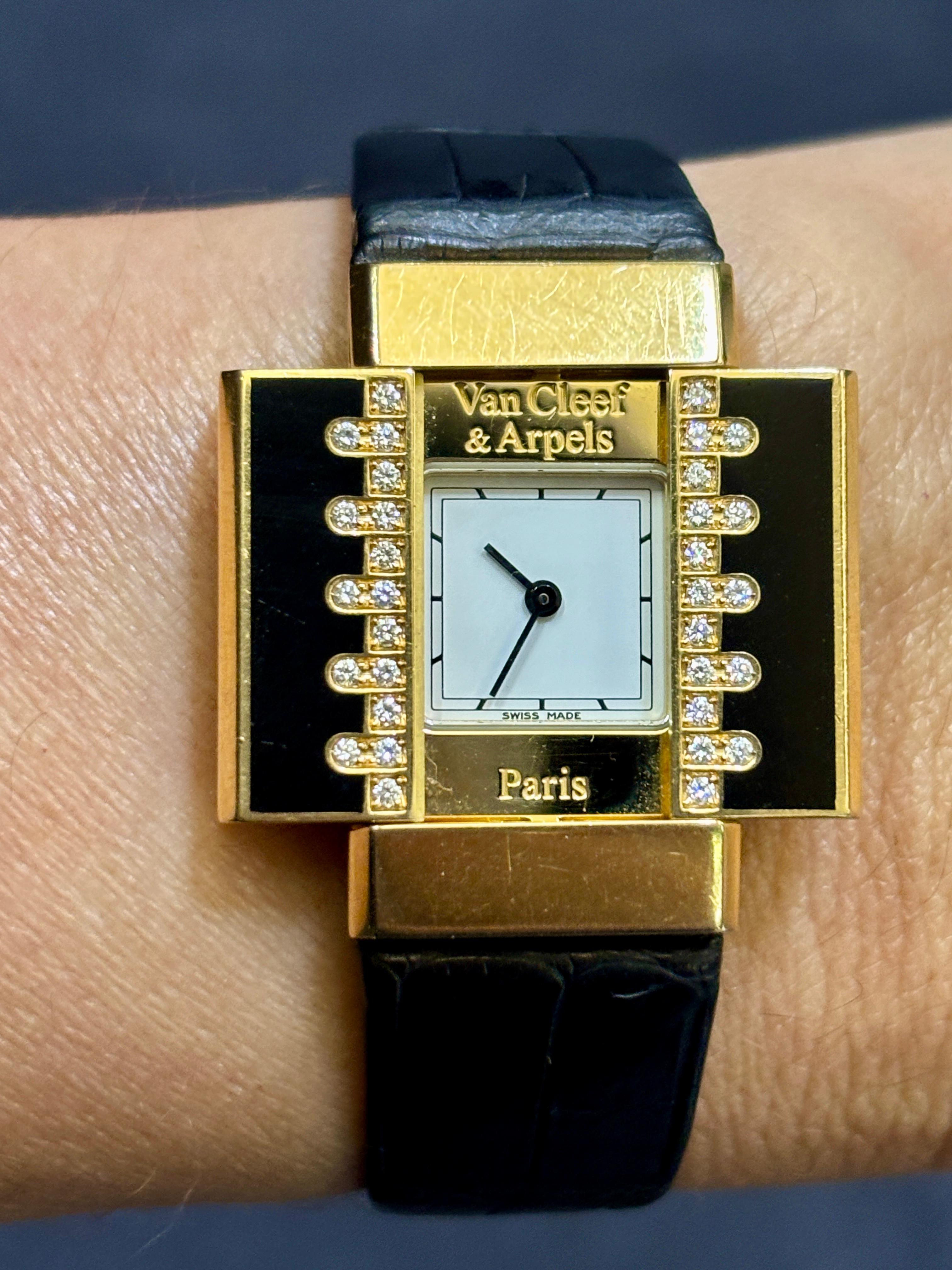 Este inusual reloj Van Cleef & Arpels tiene una tapa deslizante rectangular adornada con esmalte y diamantes. La esfera rectangular del reloj mide 1,8 cm x 3 cm cuando está cerrada y 3 cm x 3 cm cuando está abierta. Este reloj de cuarzo tiene sus