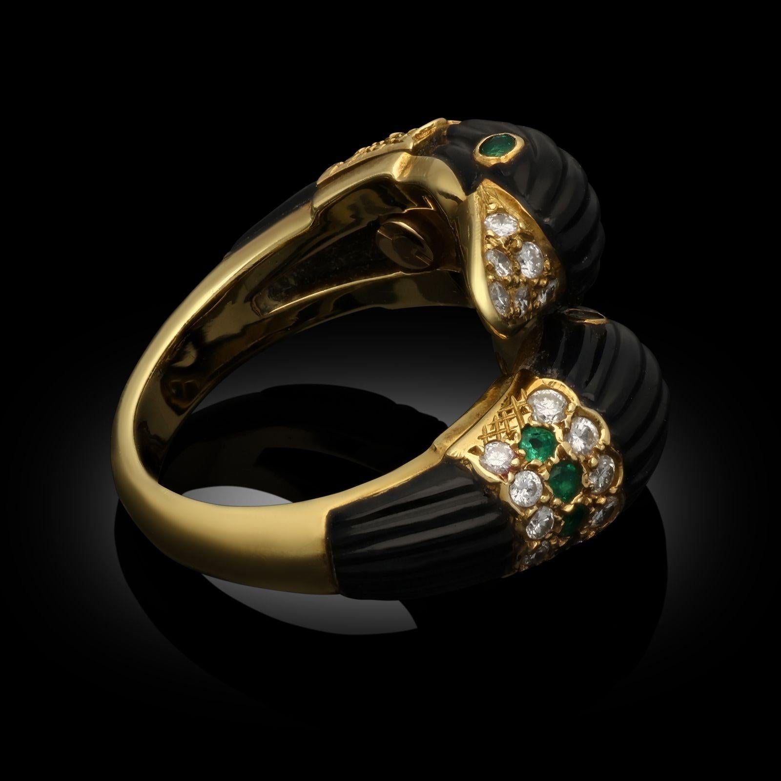 A whimsical double headed swan ring by Van Cleef & Arpels c.1970s, the bypass style ring in 18ct yellow gold designed as two matching swans heads crossing over each other and facing opposite directions, formed of carved and fluted black onyx, the