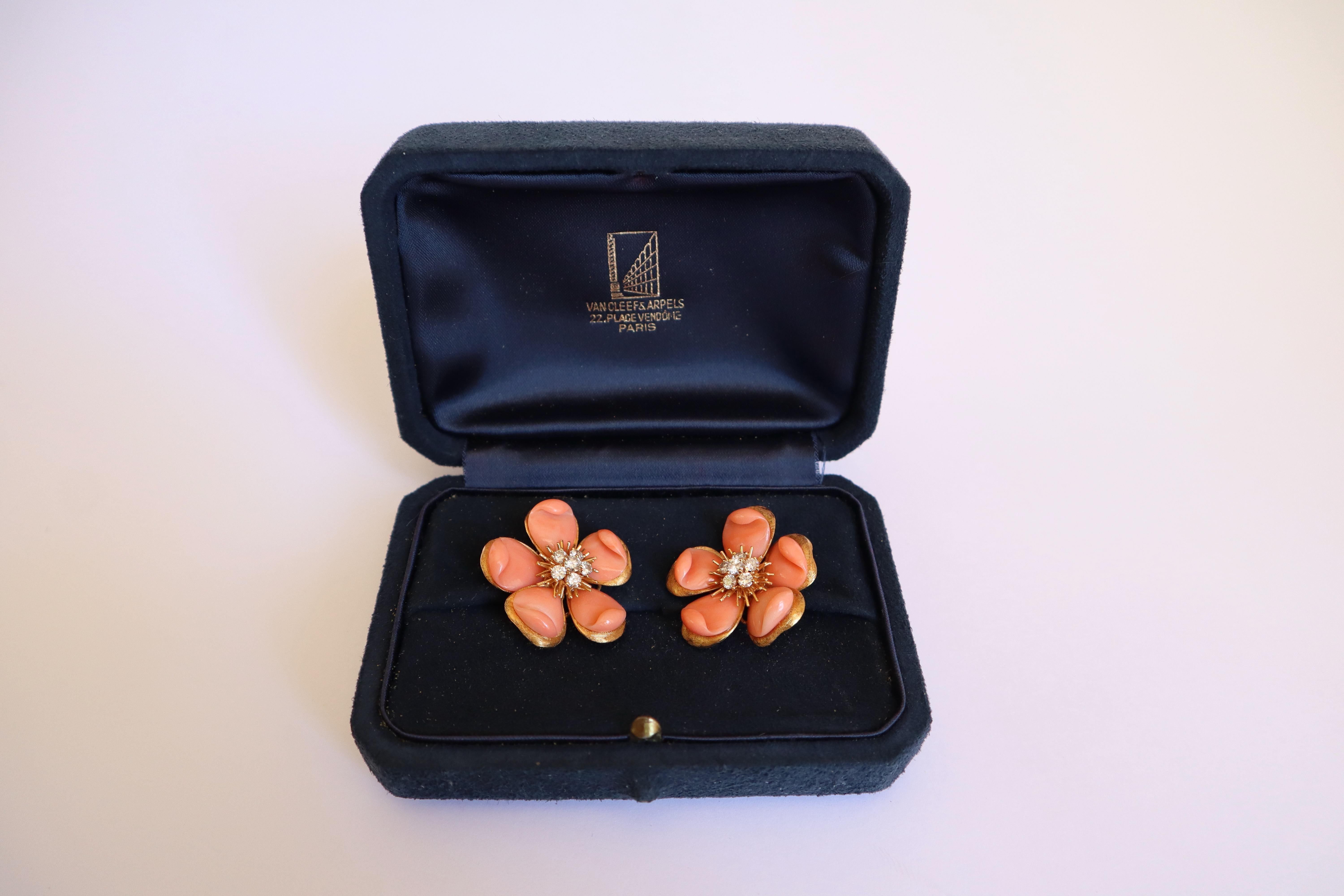 VAN CLEEF AND ARPELS Rose de Noel Legendary 18K yellow gold ear clips in the shape of blooming flowers, the five petals in 18K yellow gold are adorned with pink coral, the heart is set with 6 brilliant-cut diamonds on each clip. Approximately 1