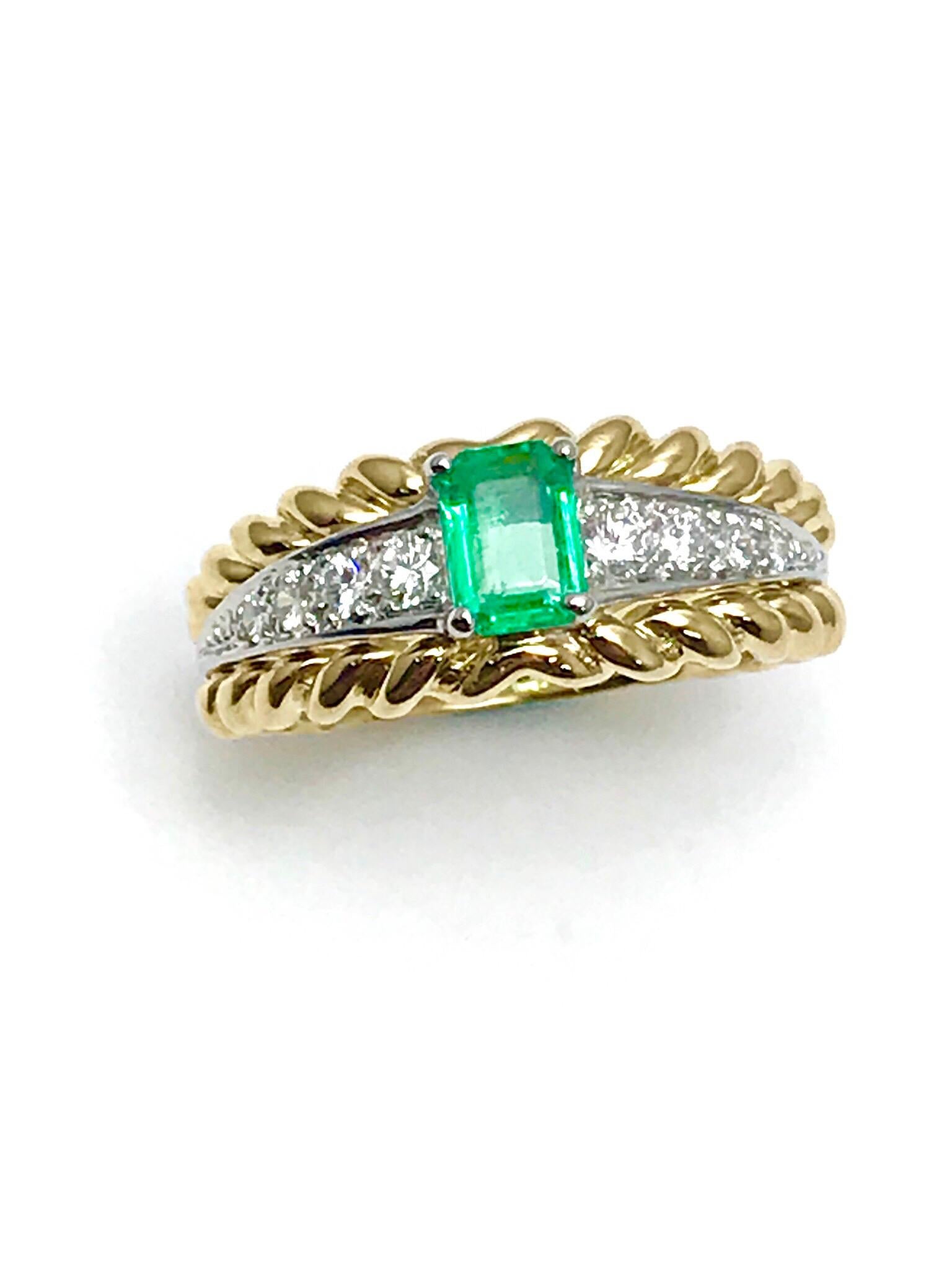 A gorgeous Van Cleef & Arpels Emerald and Diamond ring.  The .50 carat Emerald is prong set, with four diamonds to each side in platinum, between a braided gold frame, creating a split shank.  The Diamonds are round brilliant cut and have a total