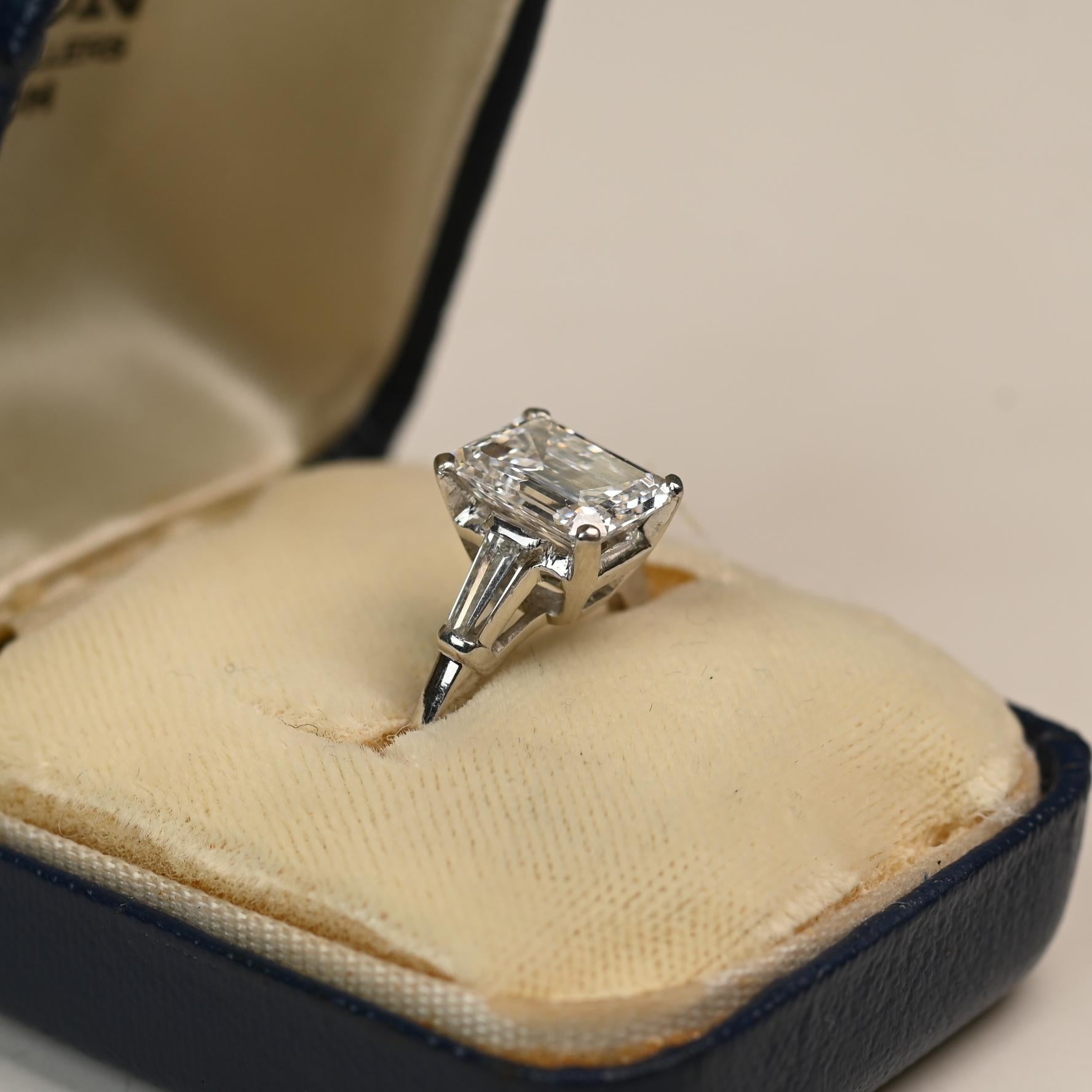 Magnifique bague Van Cleef & Arpels ornée d'un diamant taille émeraude certifié GIA pesant environ 2,40 carats. Cette pierre exceptionnelle est classée couleur E et pureté VVS2, affichant une brillance et une pureté exceptionnelles. Deux diamants