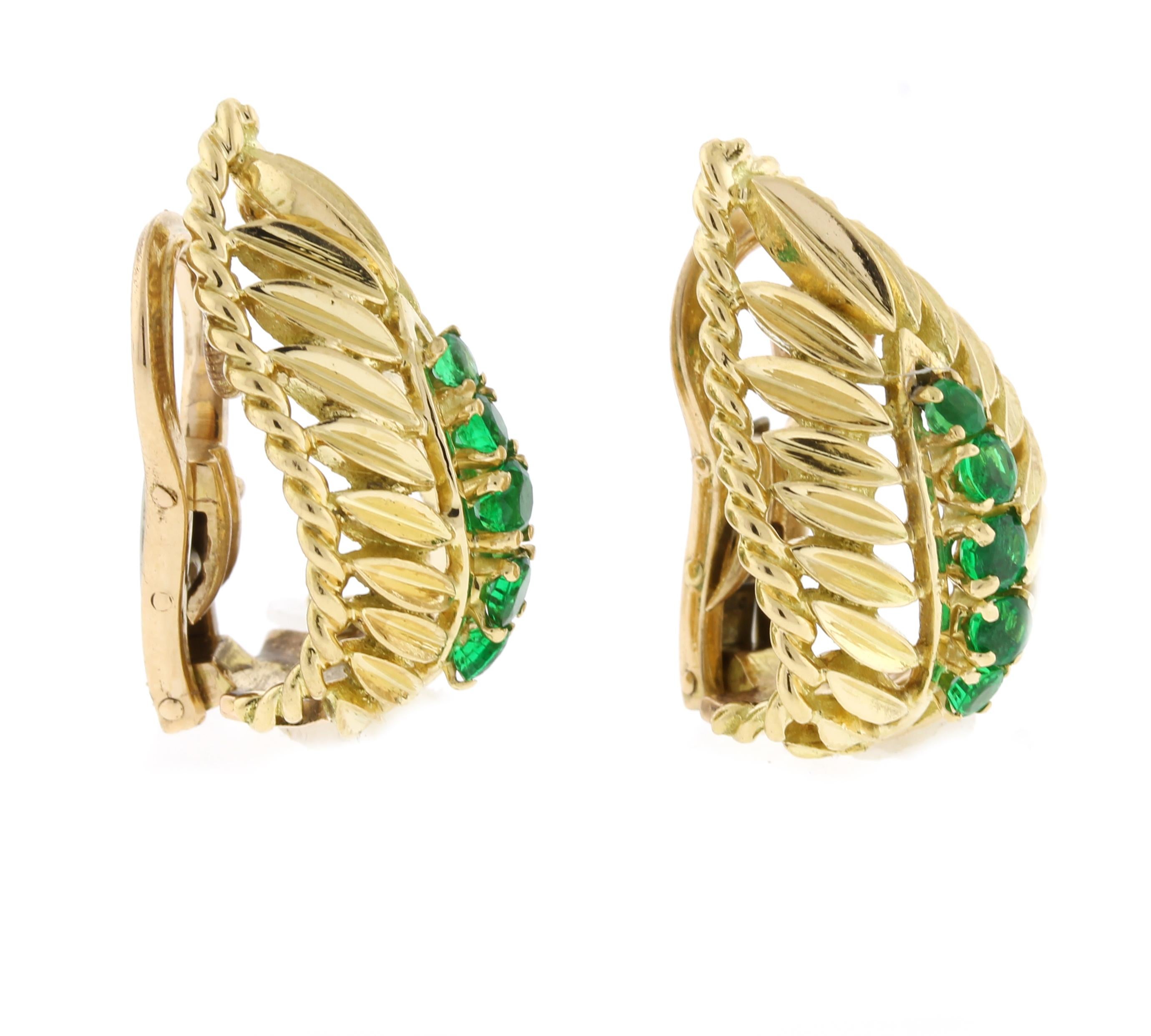 From Van Cleef & Arpels a pair of emerald and 18 karat gold emerald earclips.  The earrings are comprised of 10 vibrant green gem emeralds weighing approximately .50 carat. The earrings measure  7/8th of an inch high and 1/2inch across