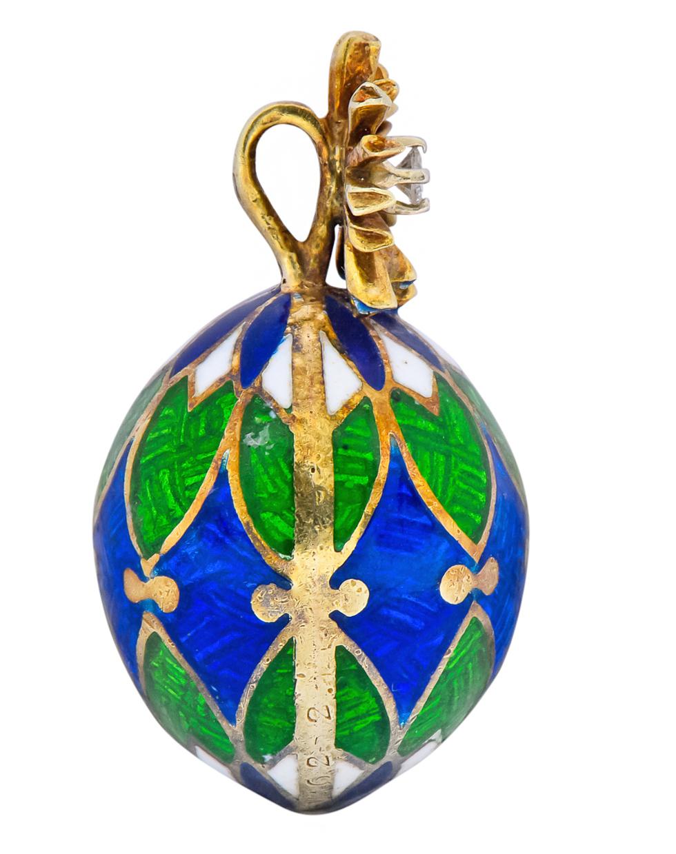 Pendant designed as an egg with pleasing pattern of blue, green, and white enamel

Topped by a radiating starburst motif centering a round brilliant cut diamond weighing approximately .03 carat, H color and VS clarity

Completed by concealed