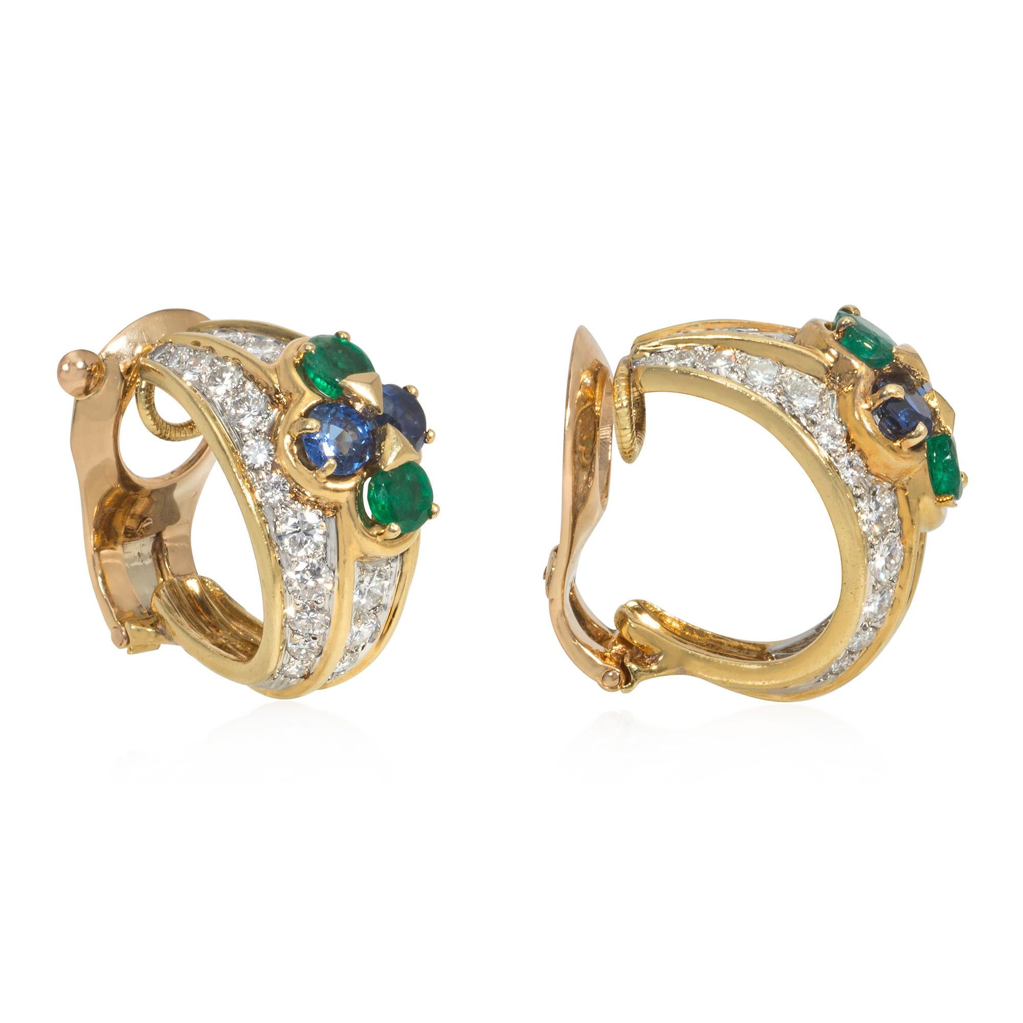 Un paio di orecchini a clip in oro e pietre preziose di proprietà, dal design a mezzo cerchio con file verticali di diamanti e una cimasa applicata di zaffiri e smeraldi, in platino e 18 carati. Van Cleef & Arpels, Francia. #28339. Marchio di